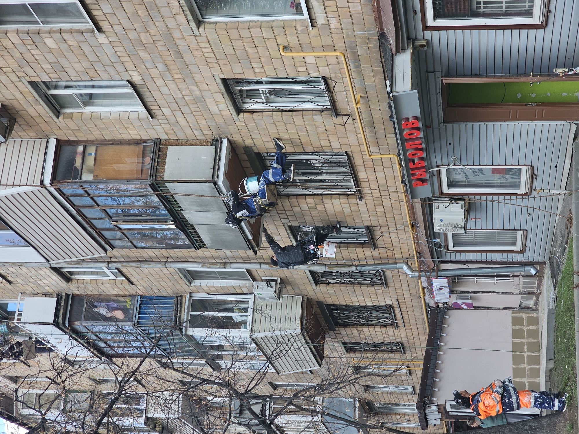 Workers paint building facade in Khimki, Russia