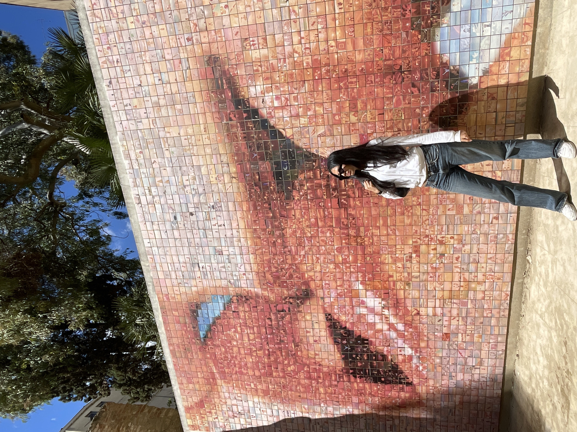 Tourists pose with Barcelona mosaic mural near cathedral