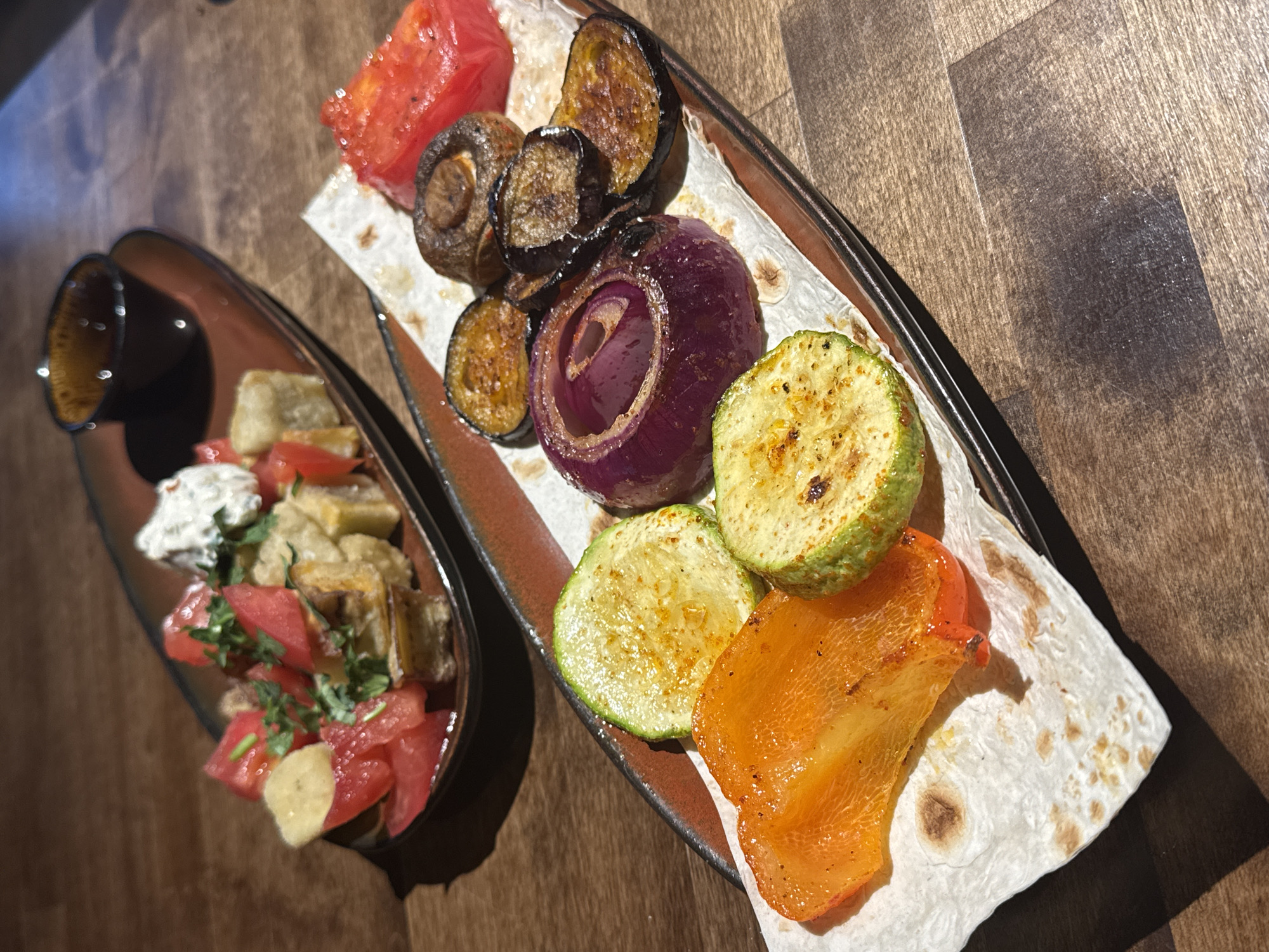 Restaurant spread of grilled vegetables, stews, and salads in Perm