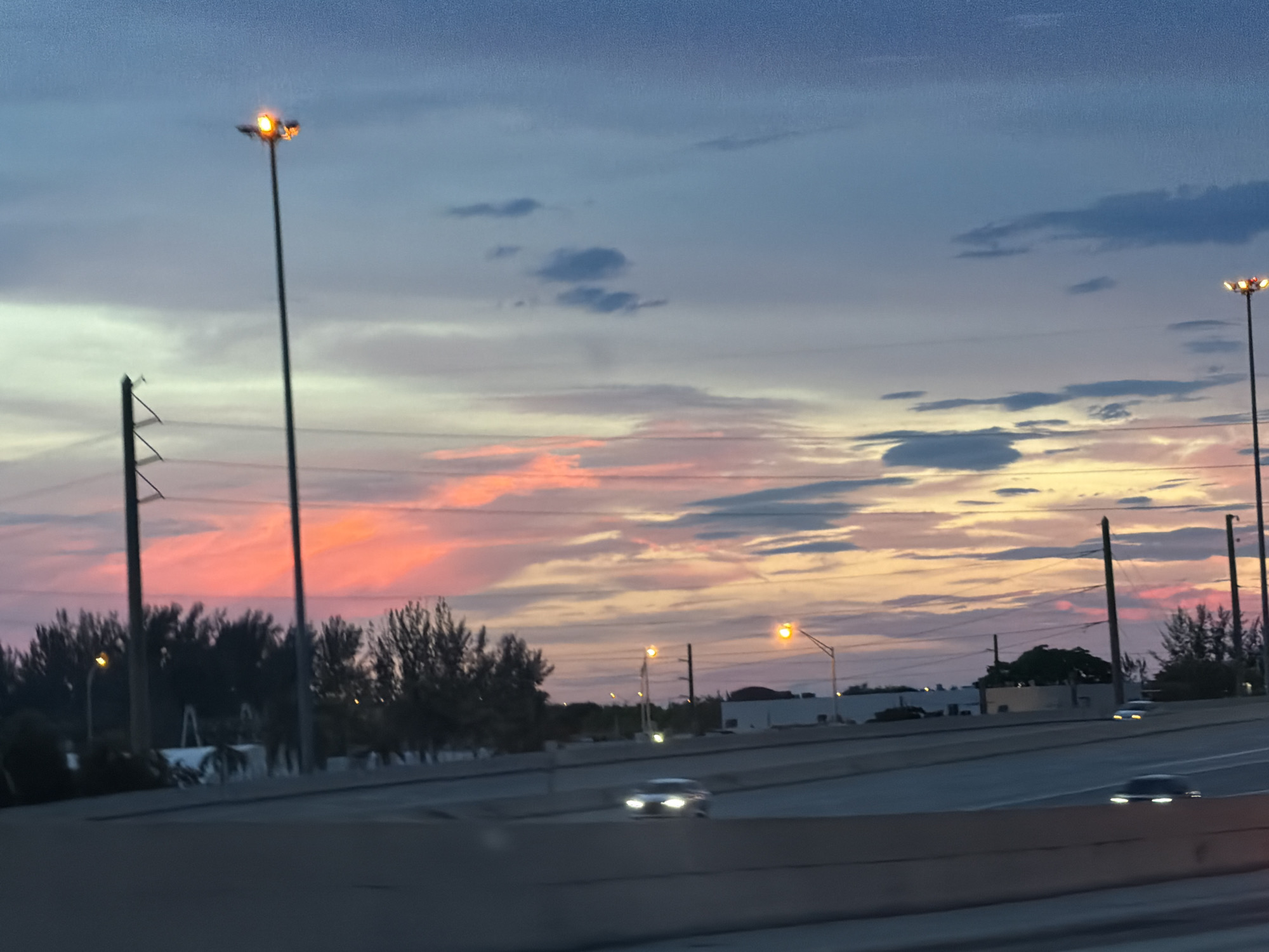 Miami highway at dusk under a colorful sunset sky