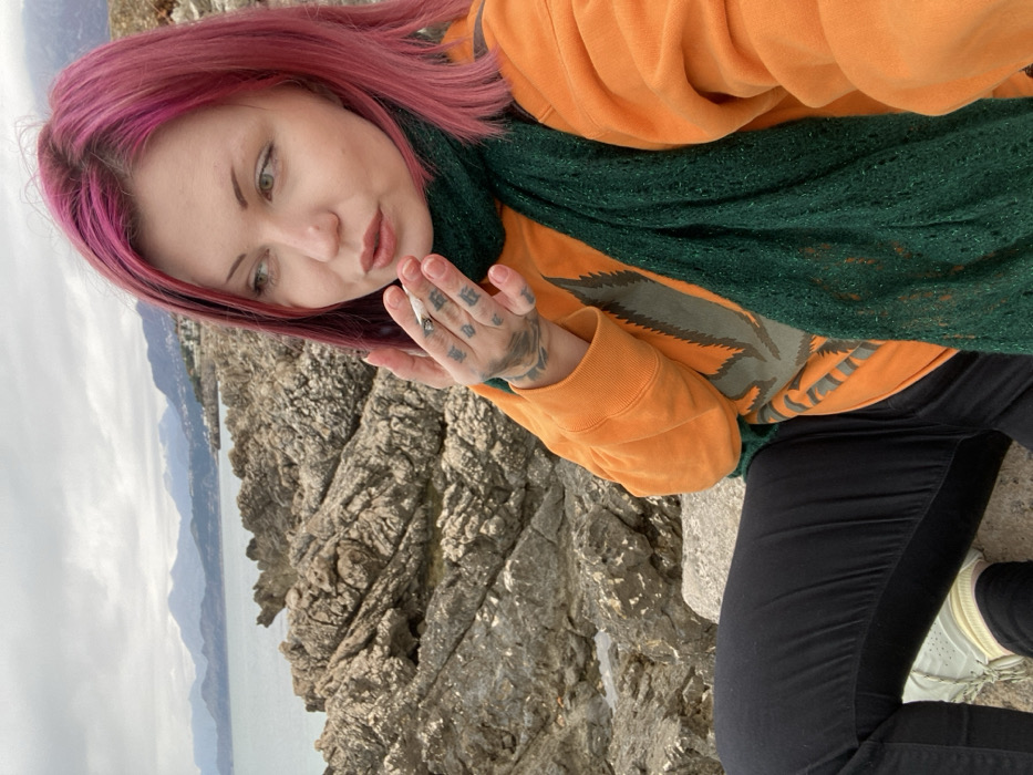 Pink-haired visitor contemplates Adriatic coastline in Bar, Montenegro
