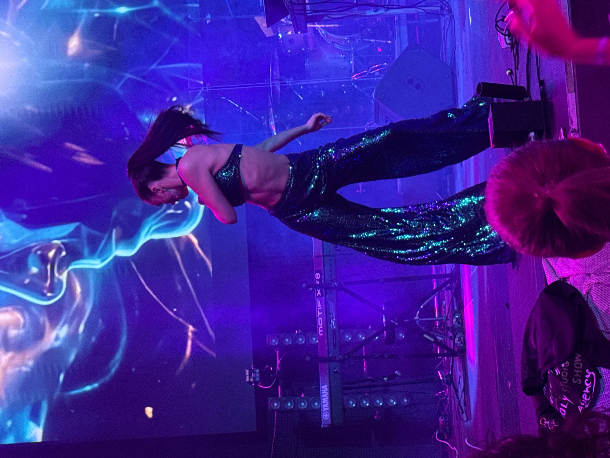 Sequined stage performers dance under colorful lights in Georgia