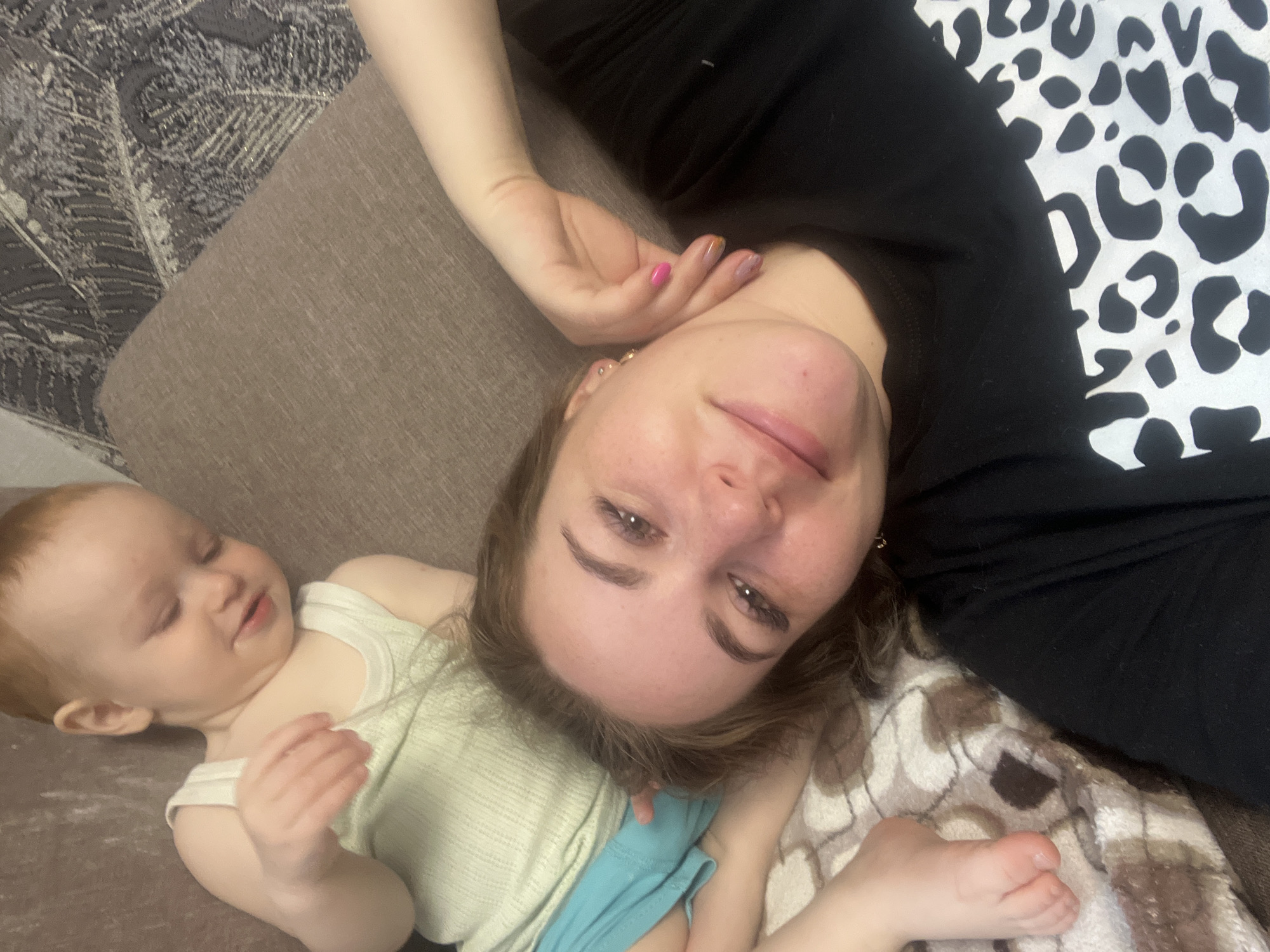 Woman and child rest on couch in Chaikovsky