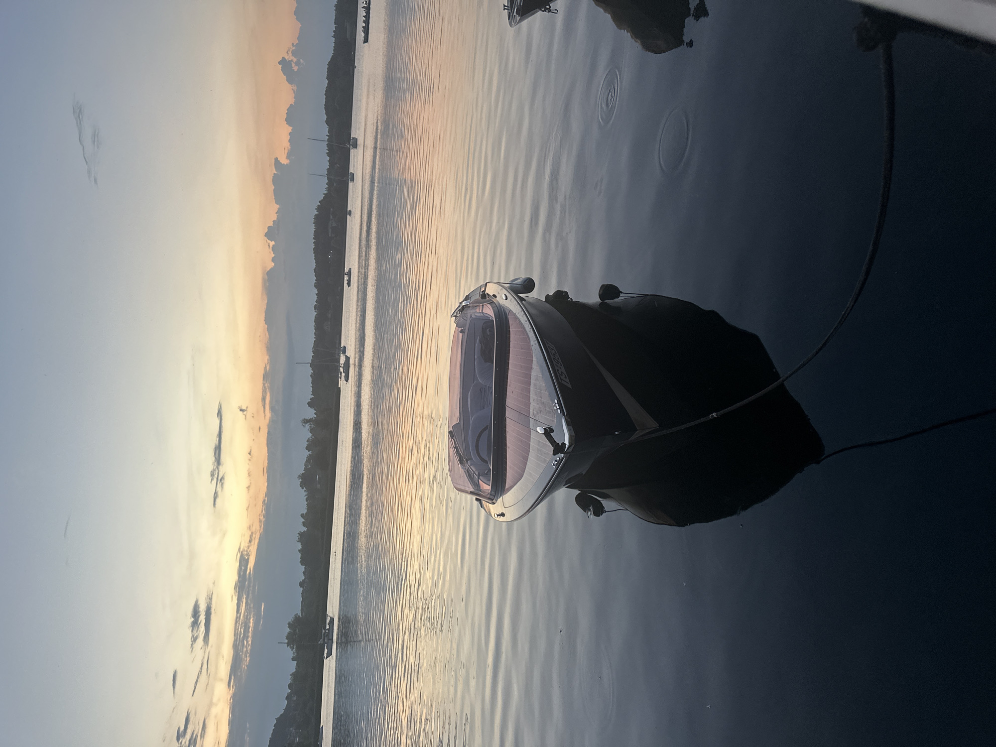 Classic wooden speedboat at anchor during a Rimsting sunset