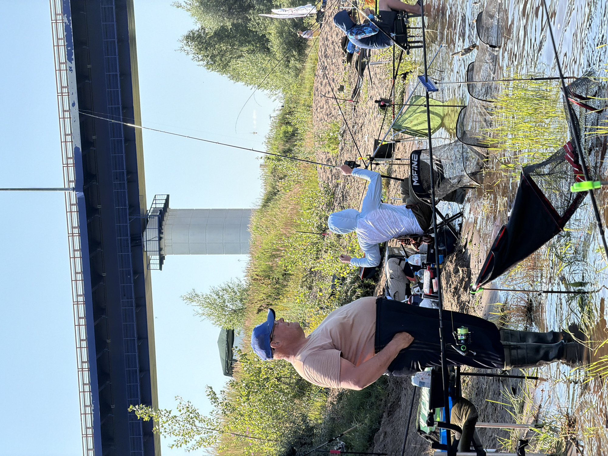 Recreational fishing on a Russian riverbank beneath a highway bridge
