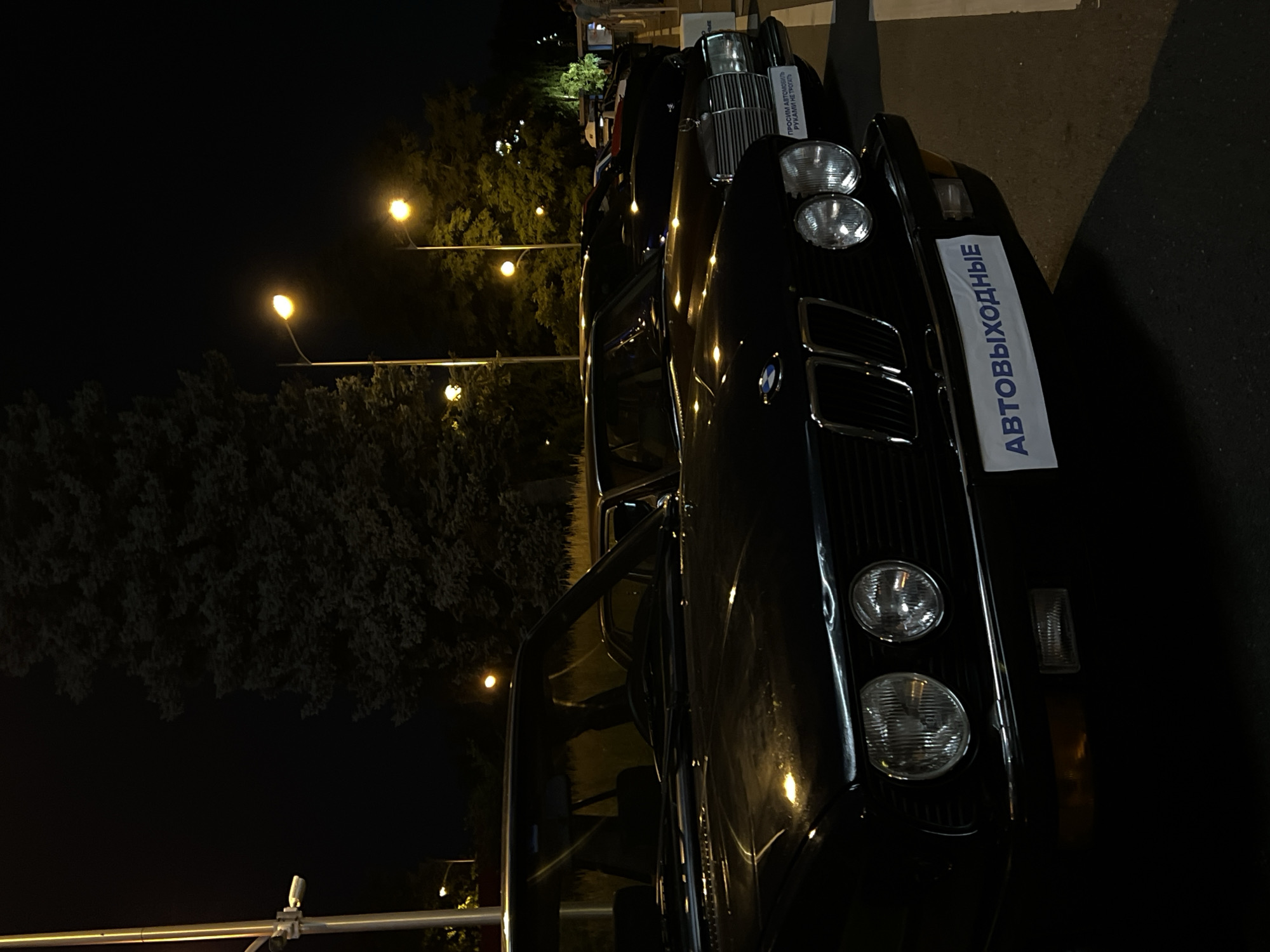 Classic and exotic cars gathered outside Moscow landmark at night