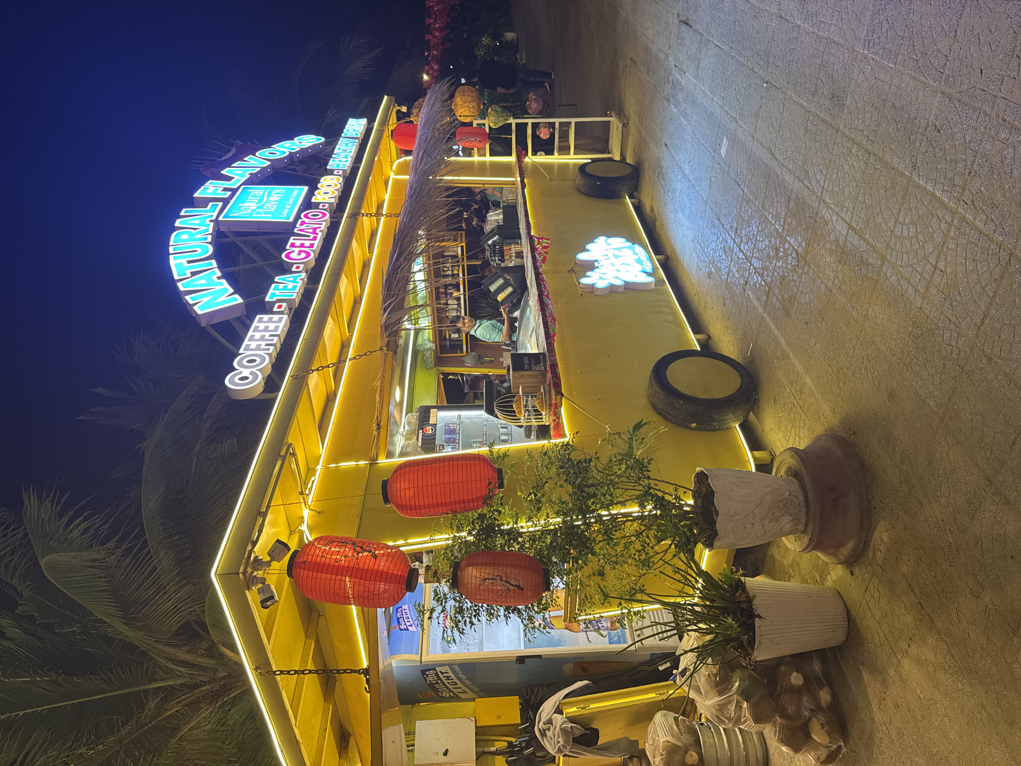 Bright Natural Flavors cafe captured at night in Vietnam