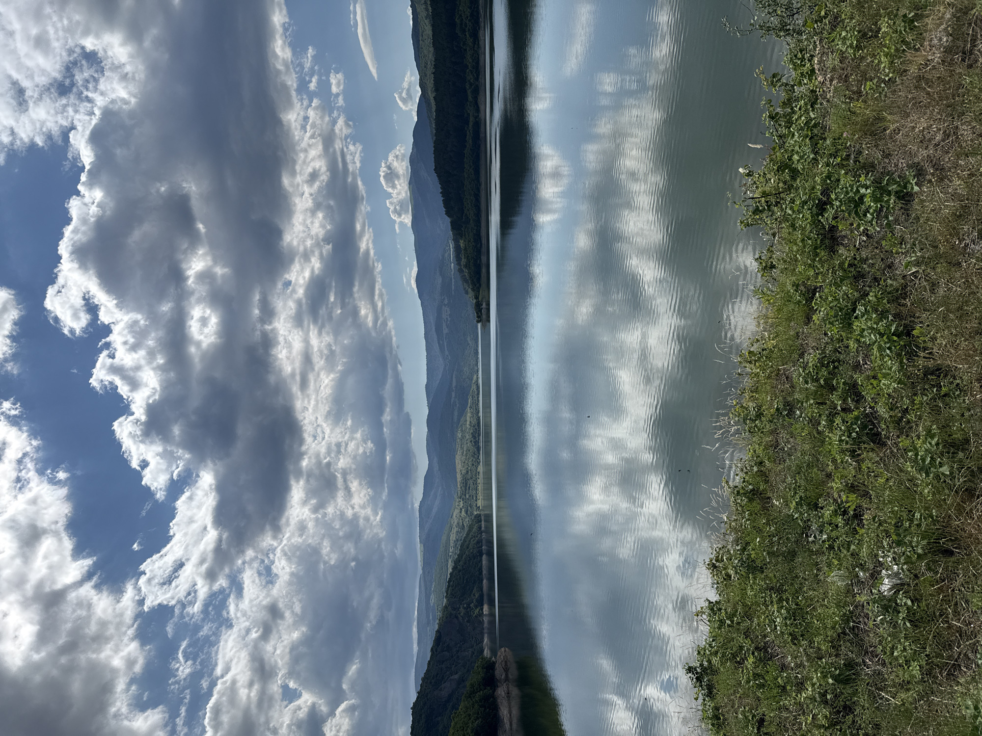 Mountain landscapes and a dam structure in lush green surroundings
