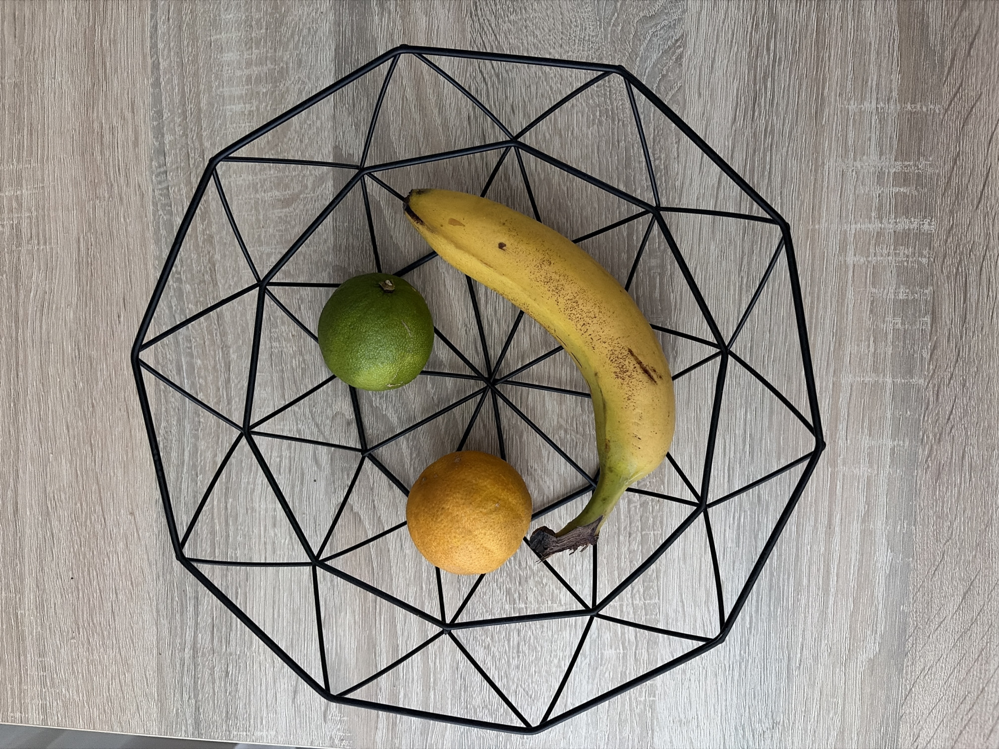 Fruit basket still life and pink slides on a wooden floor