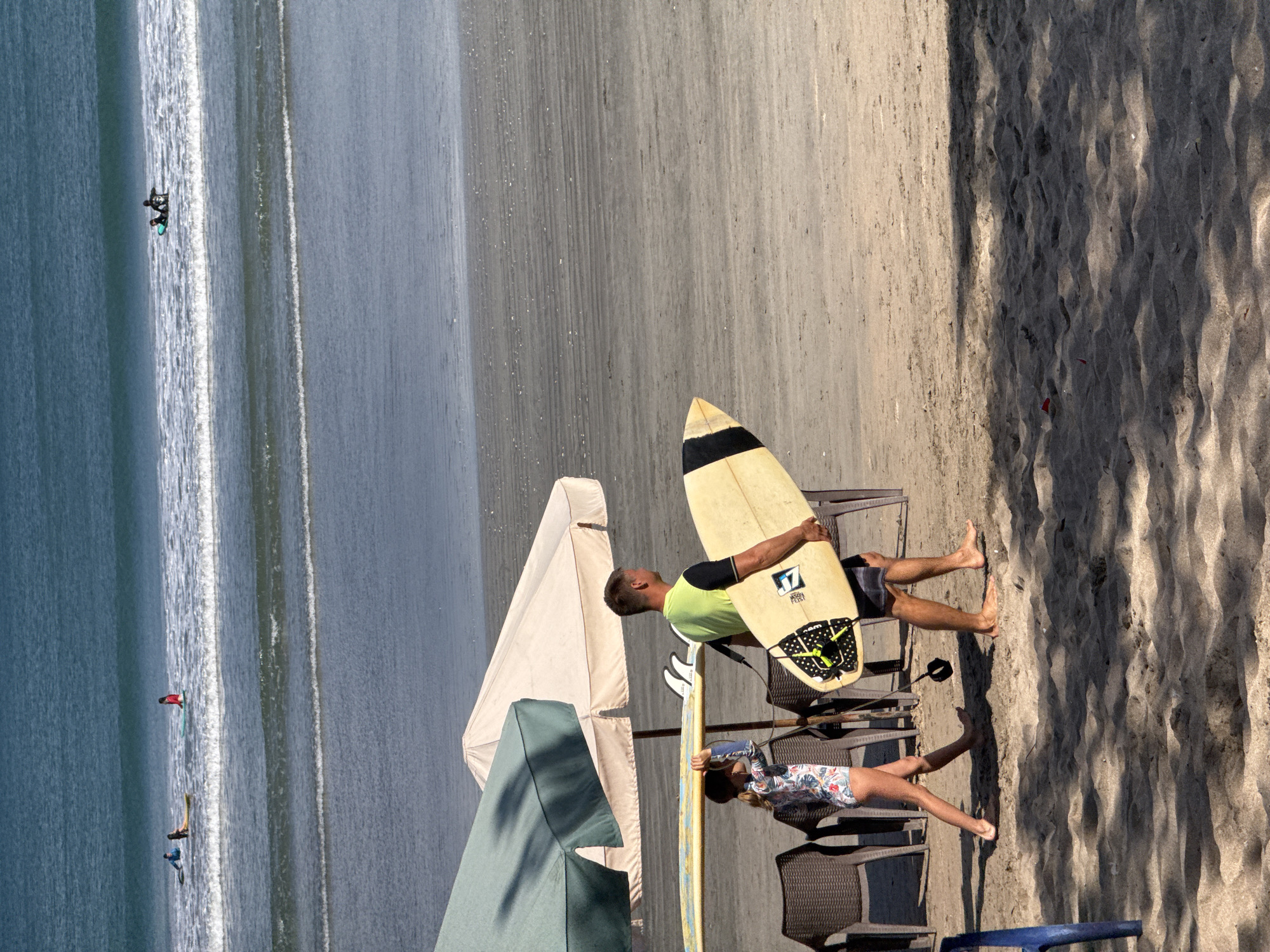 Surfers and beachgoers fill Kuta Beach on a sunny morning