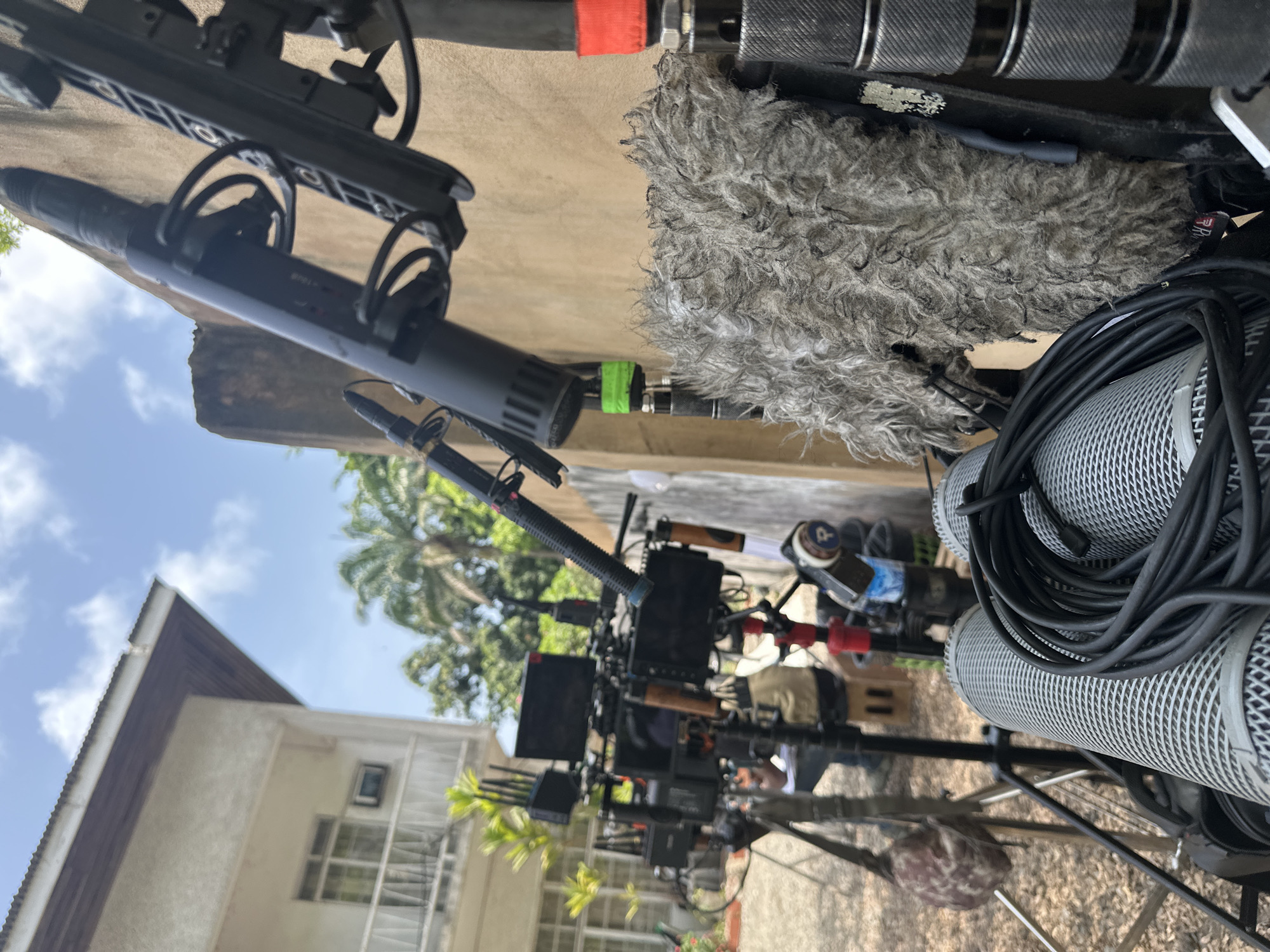 Film crew sets up equipment near parked truck in Lagos
