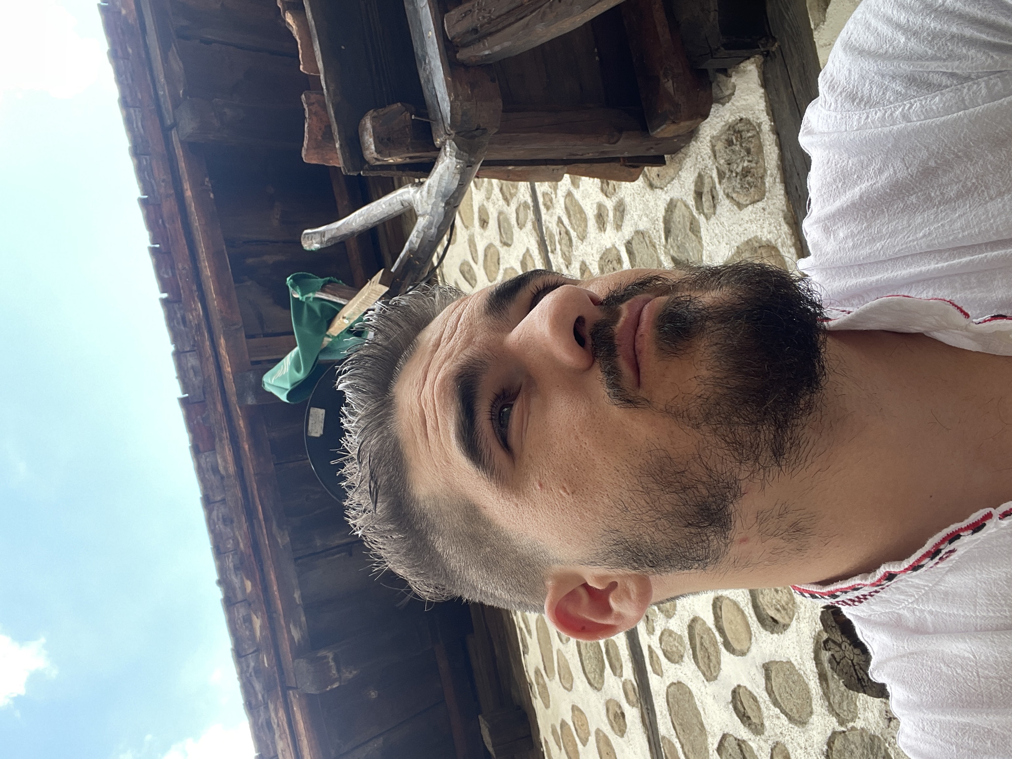 Selfies in traditional dress at a stone building, with casual text graphics