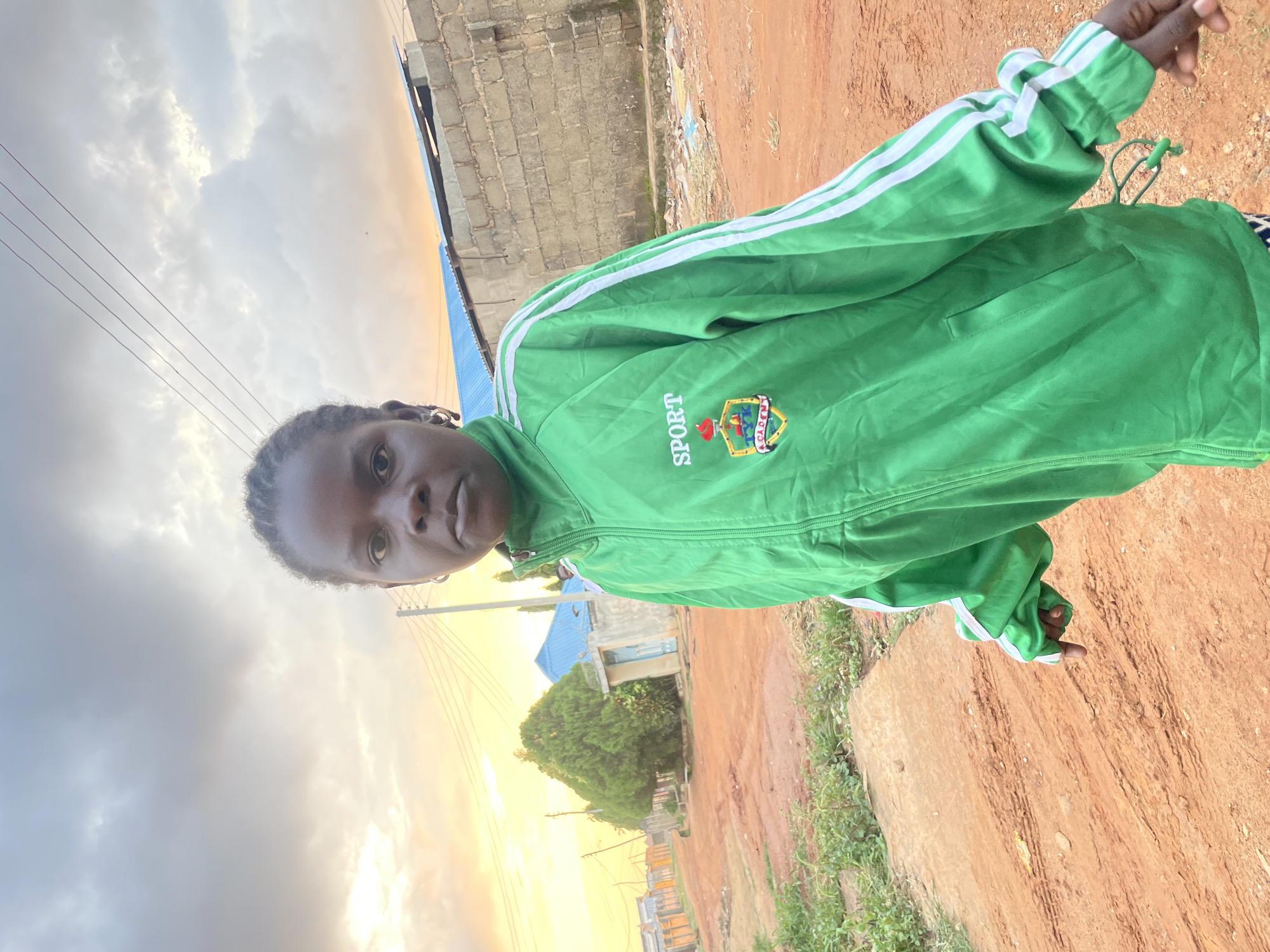 Green jacket, dirt road, Rido — a quiet Nigerian street moment.