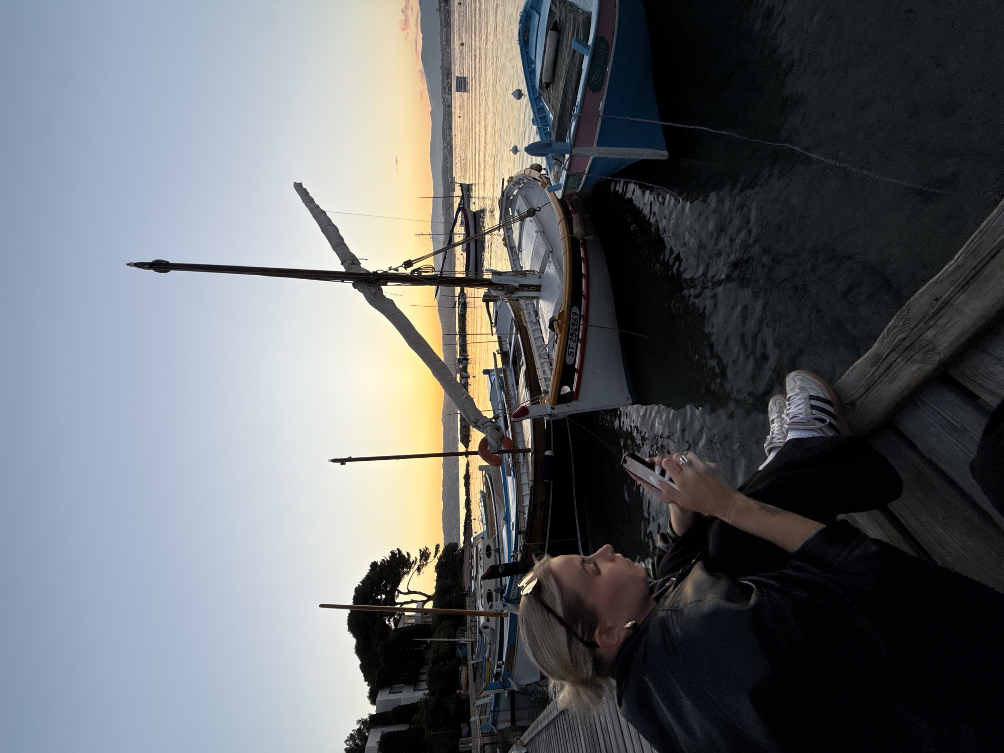 Woman uses smartphone on pier in Antibes, France