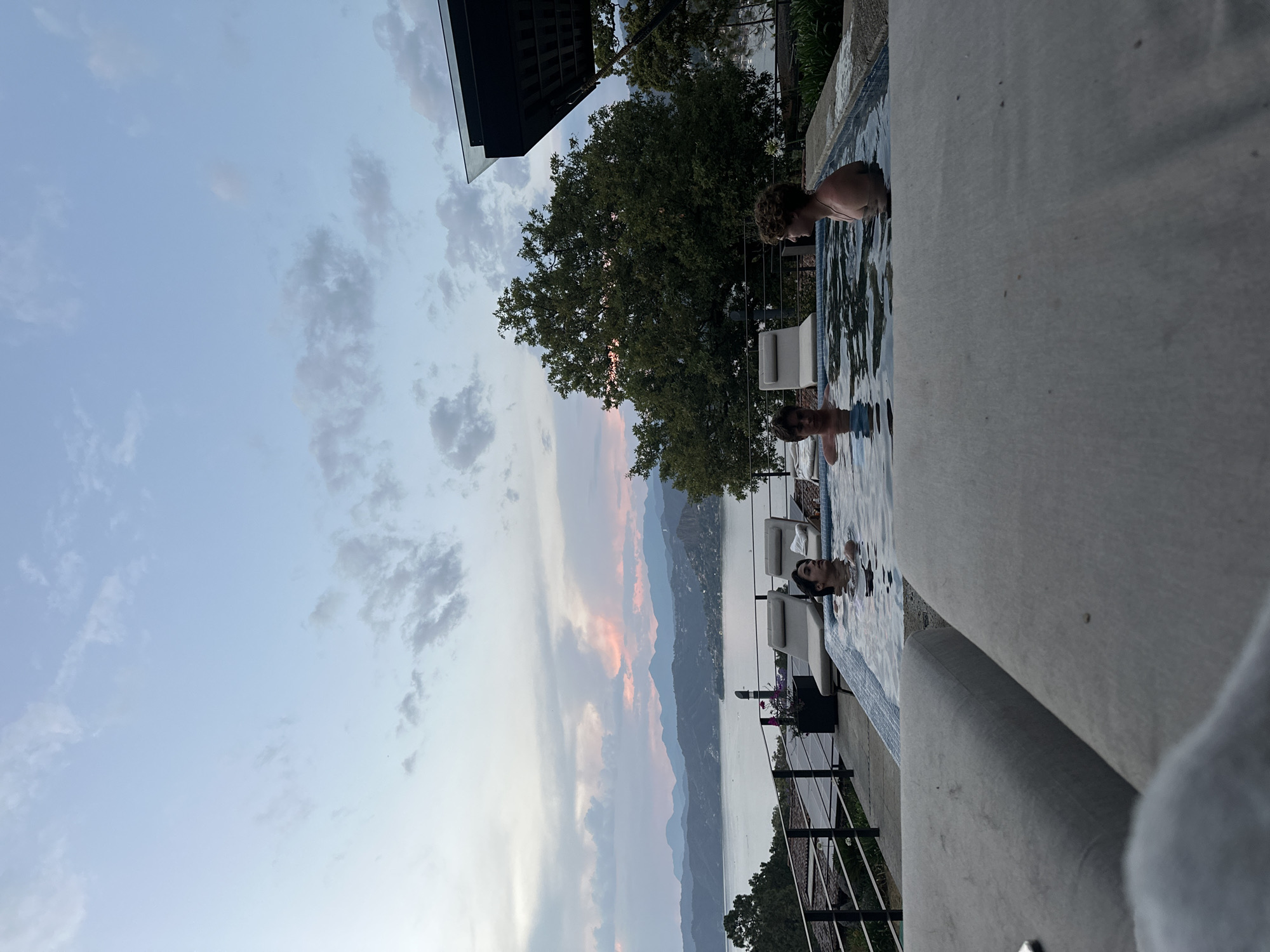 People swim at scenic mountain lake overlook during sunset
