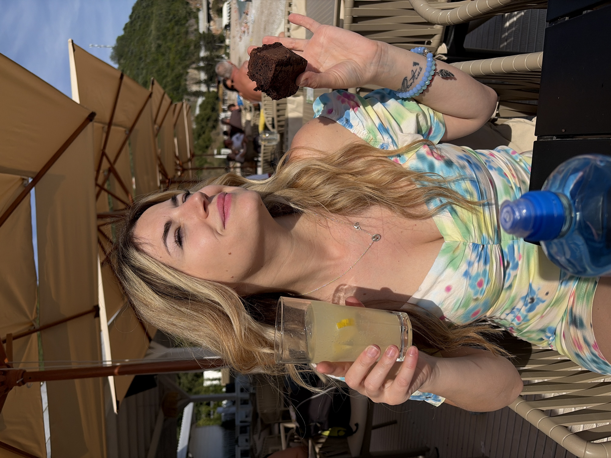 Woman enjoys sunny afternoon at beachside cafe in Budva