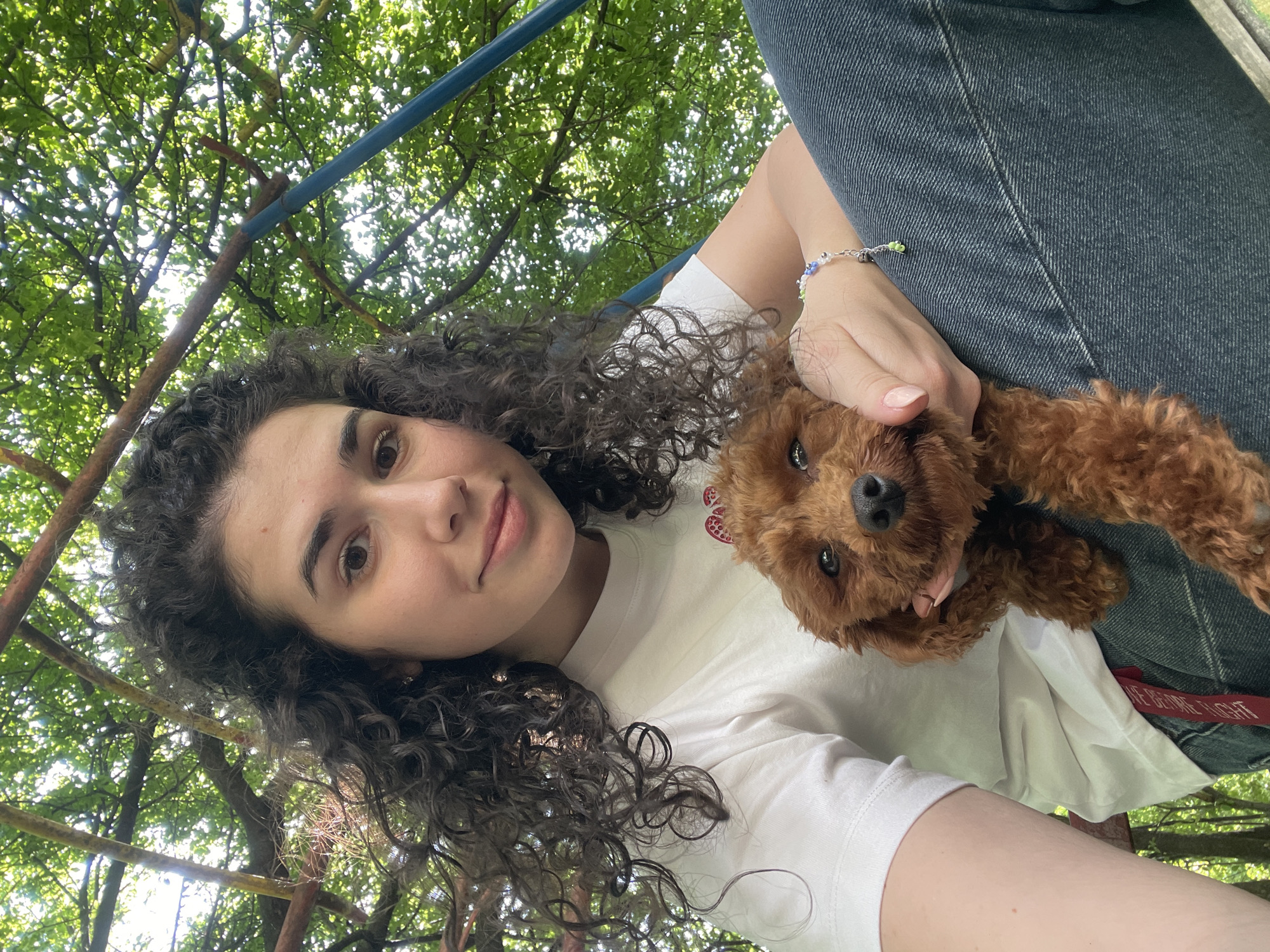 Woman enjoys afternoon park outing with small dog in Sofia