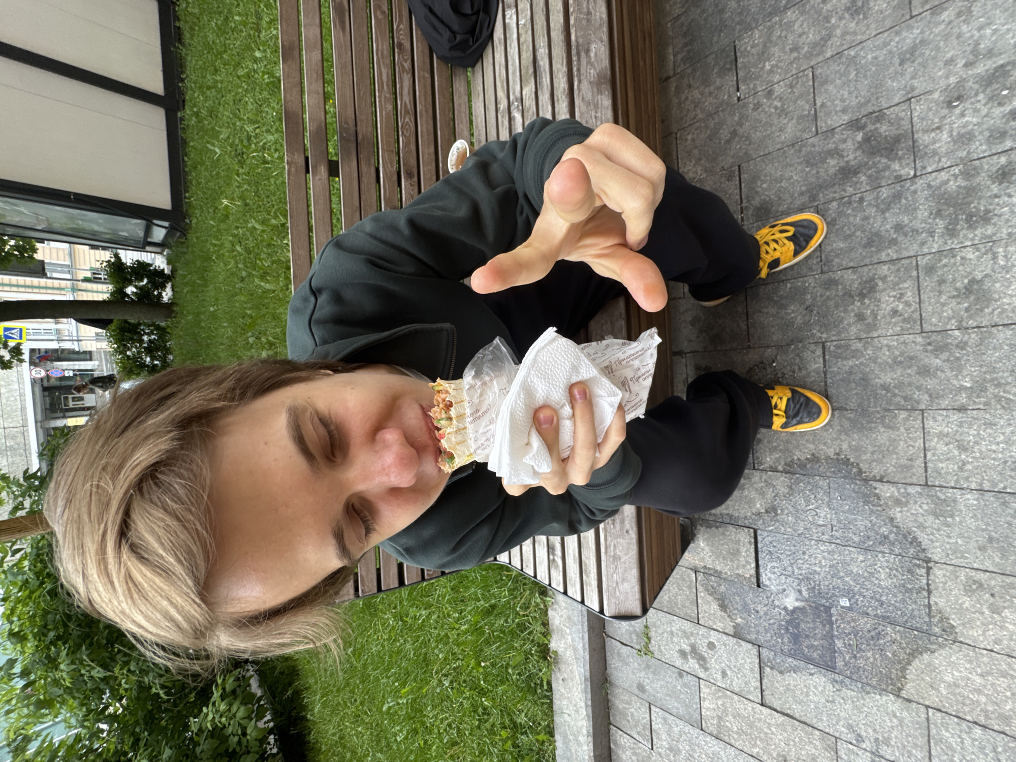 Person enjoys shawarma lunch on Moscow park bench