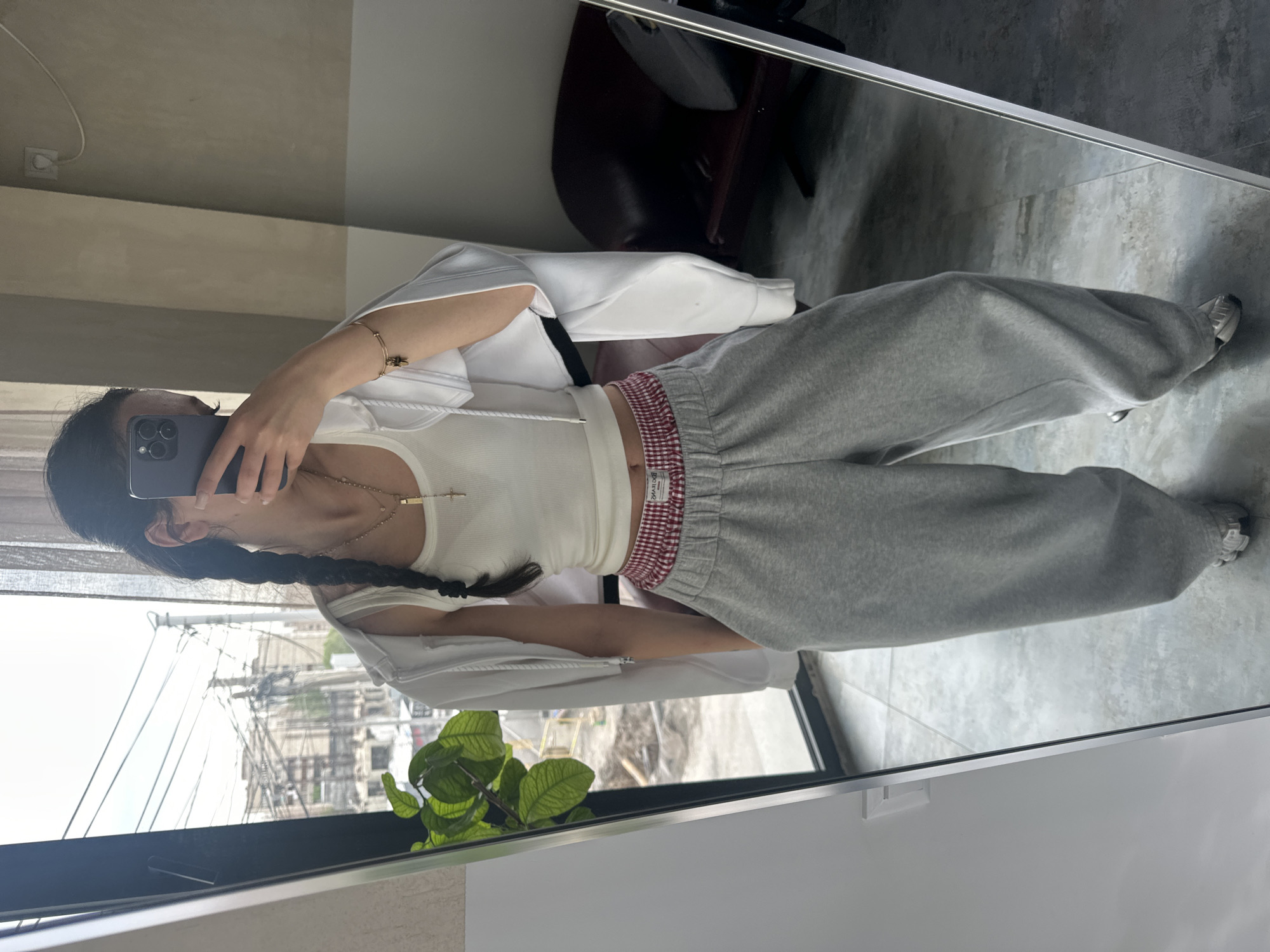Person takes mirror selfies in white hoodie in Zovuni