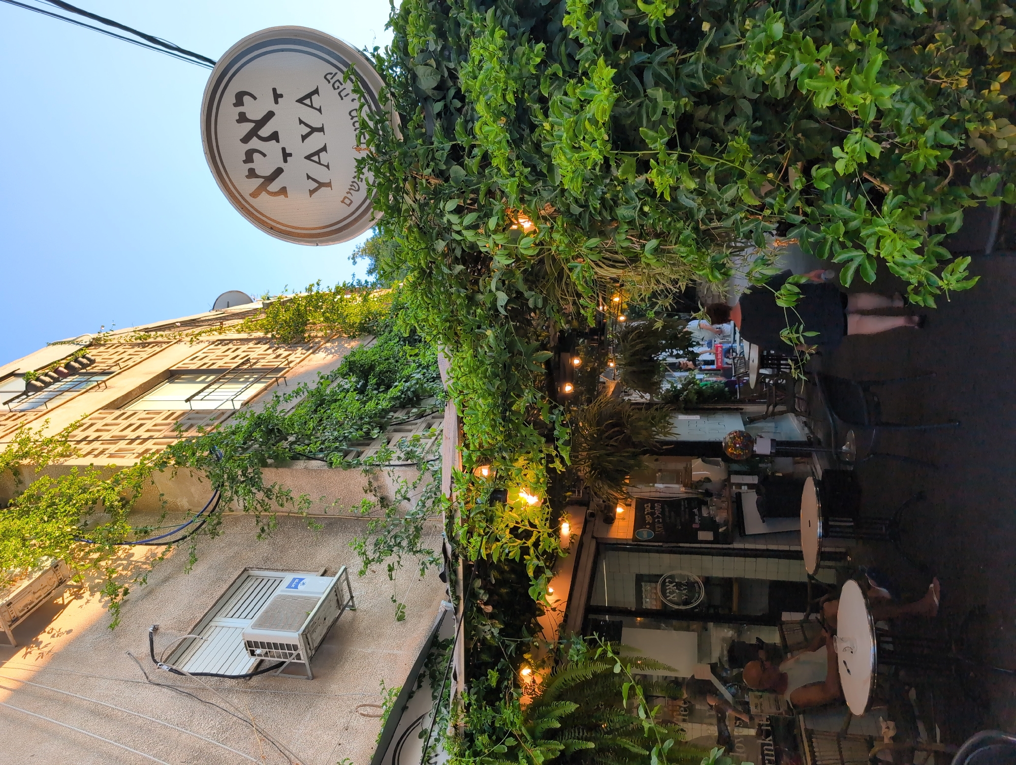 YAYA café terrace with vine-covered facade in Ramat Gan