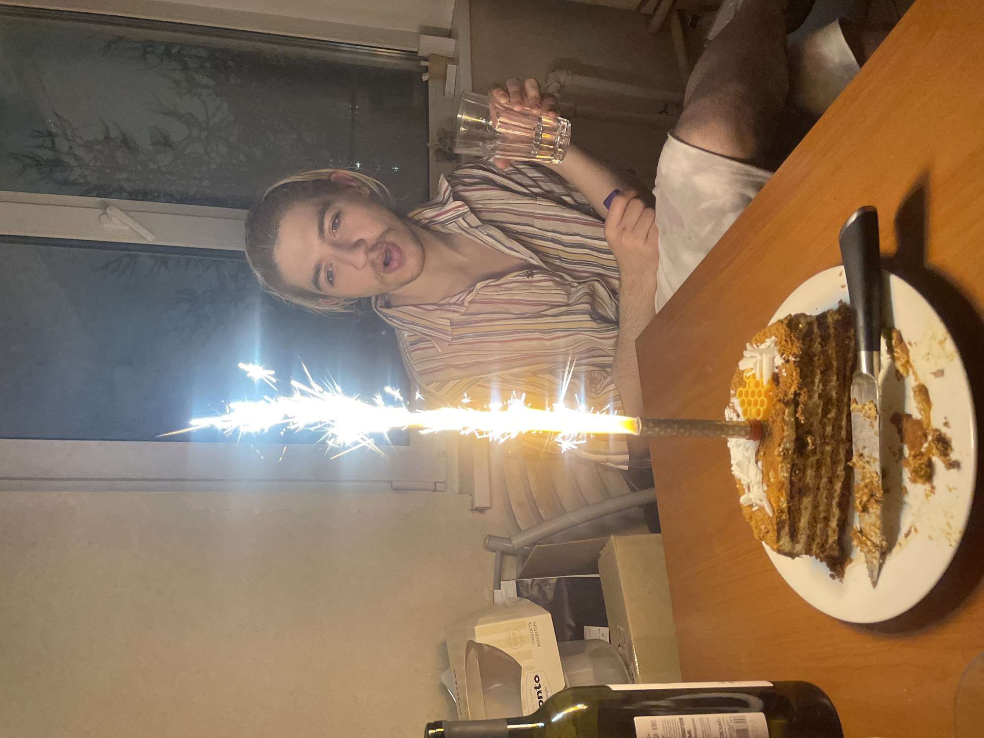 Young man celebrates with cake in Moscow indoor gathering