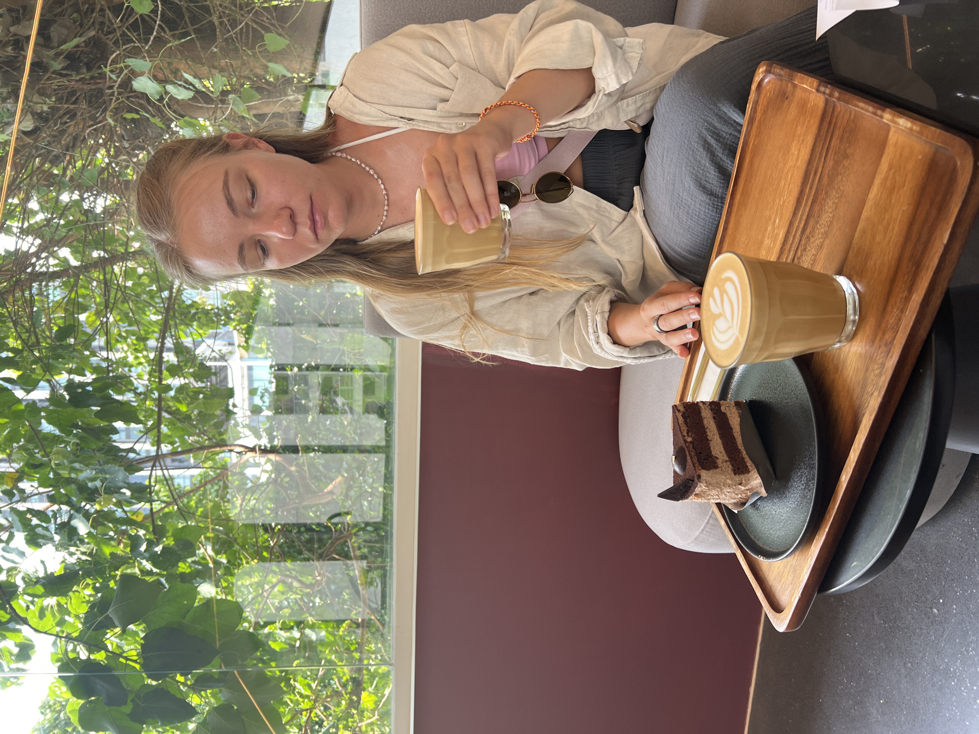 Woman pours coffee at Bangkok cafe during morning hours