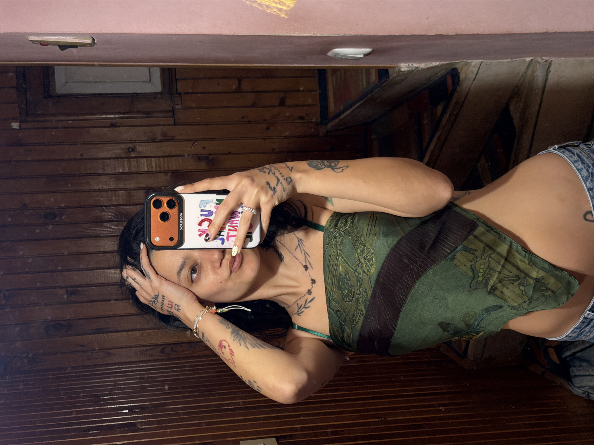 Woman takes mirror selfies in wood-paneled indoor setting