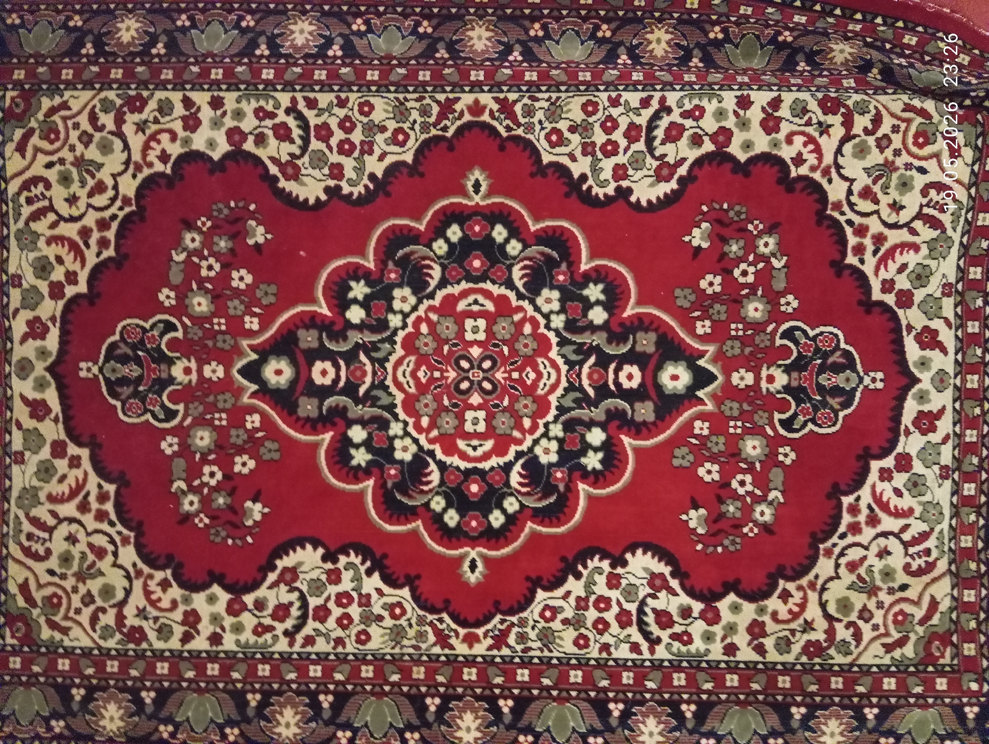 Decorative red rug with floral medallion pattern documented