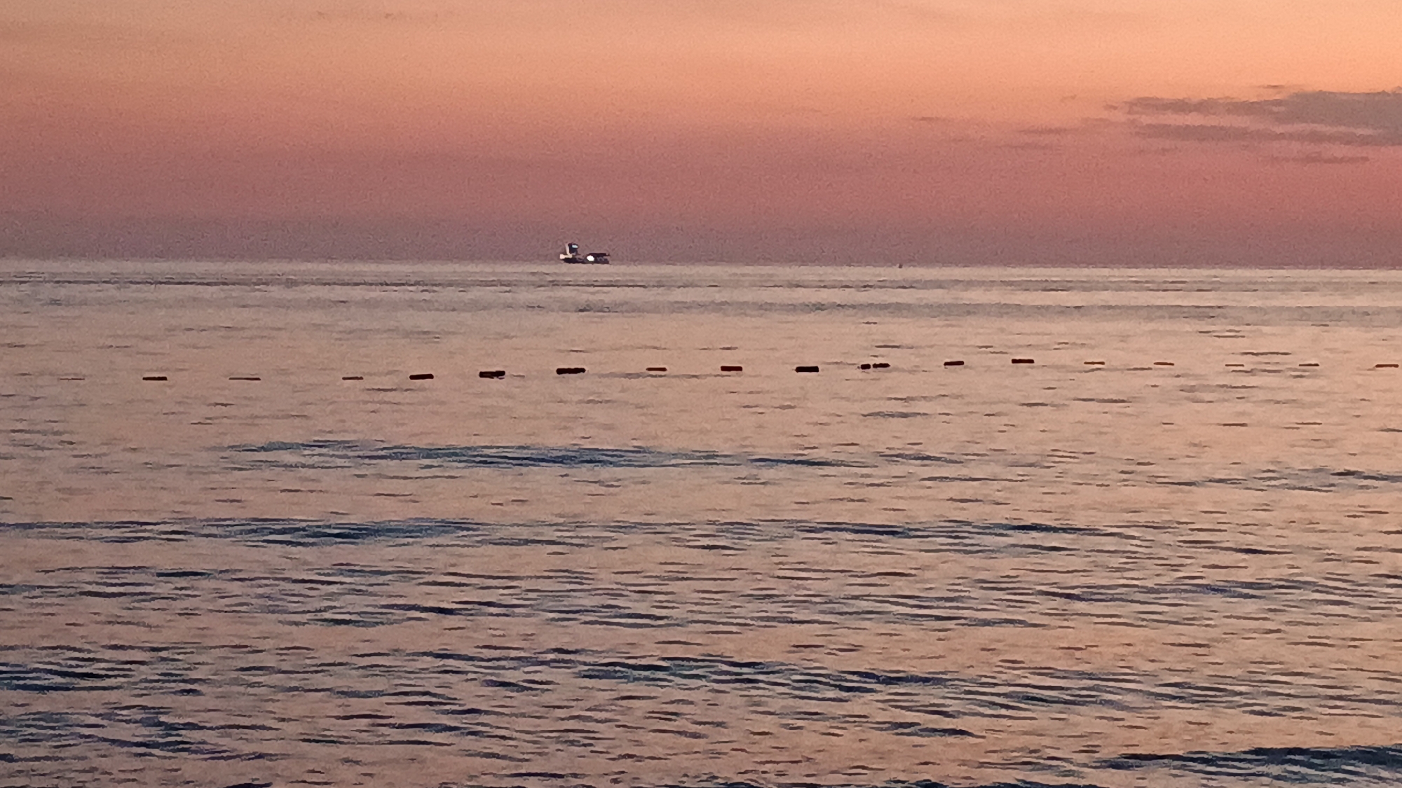 Coastal sunset gathering draws beachgoers, diners, anglers to waterfront