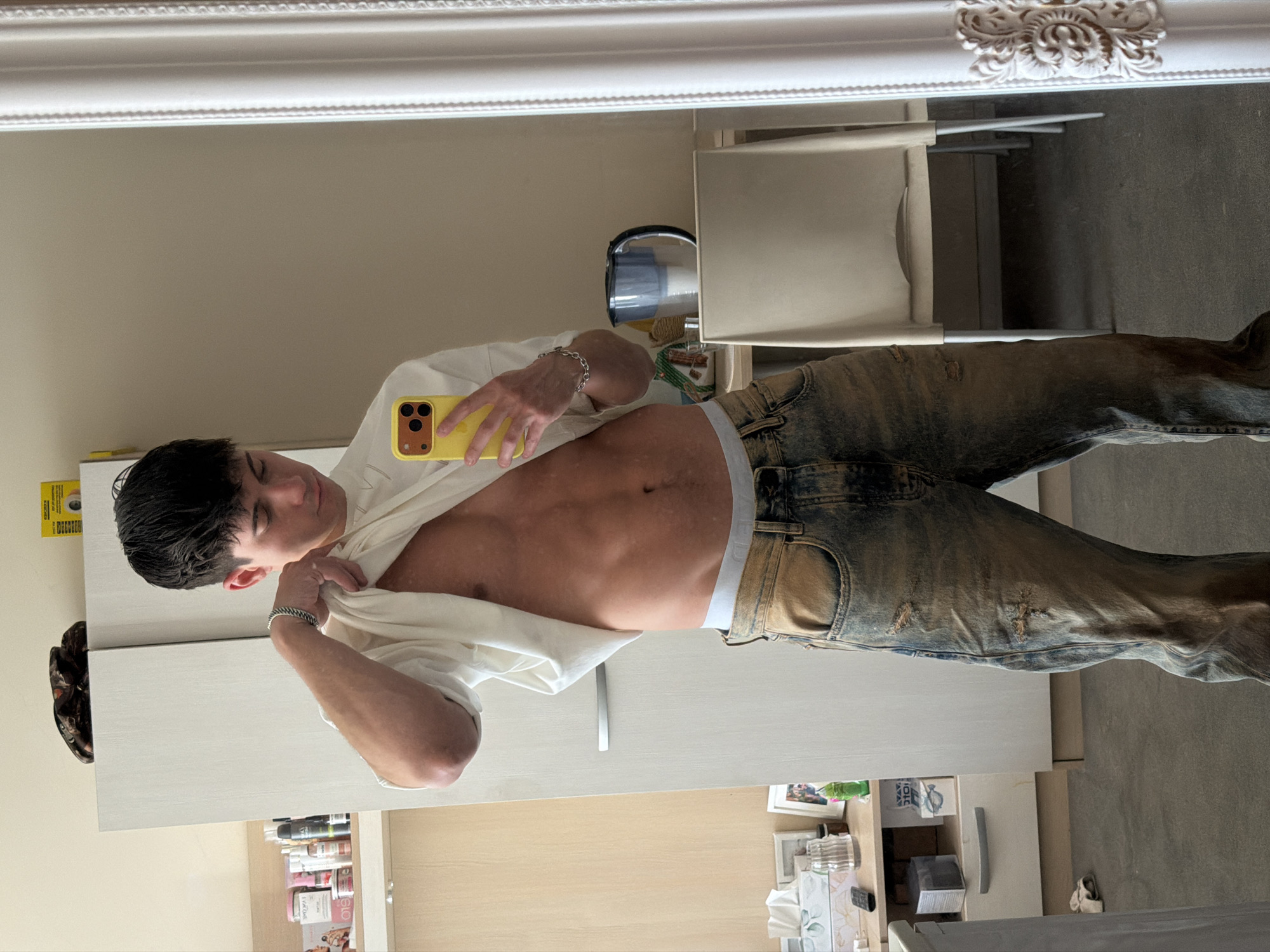 Young man takes mirror selfies with yellow phone in Sofia