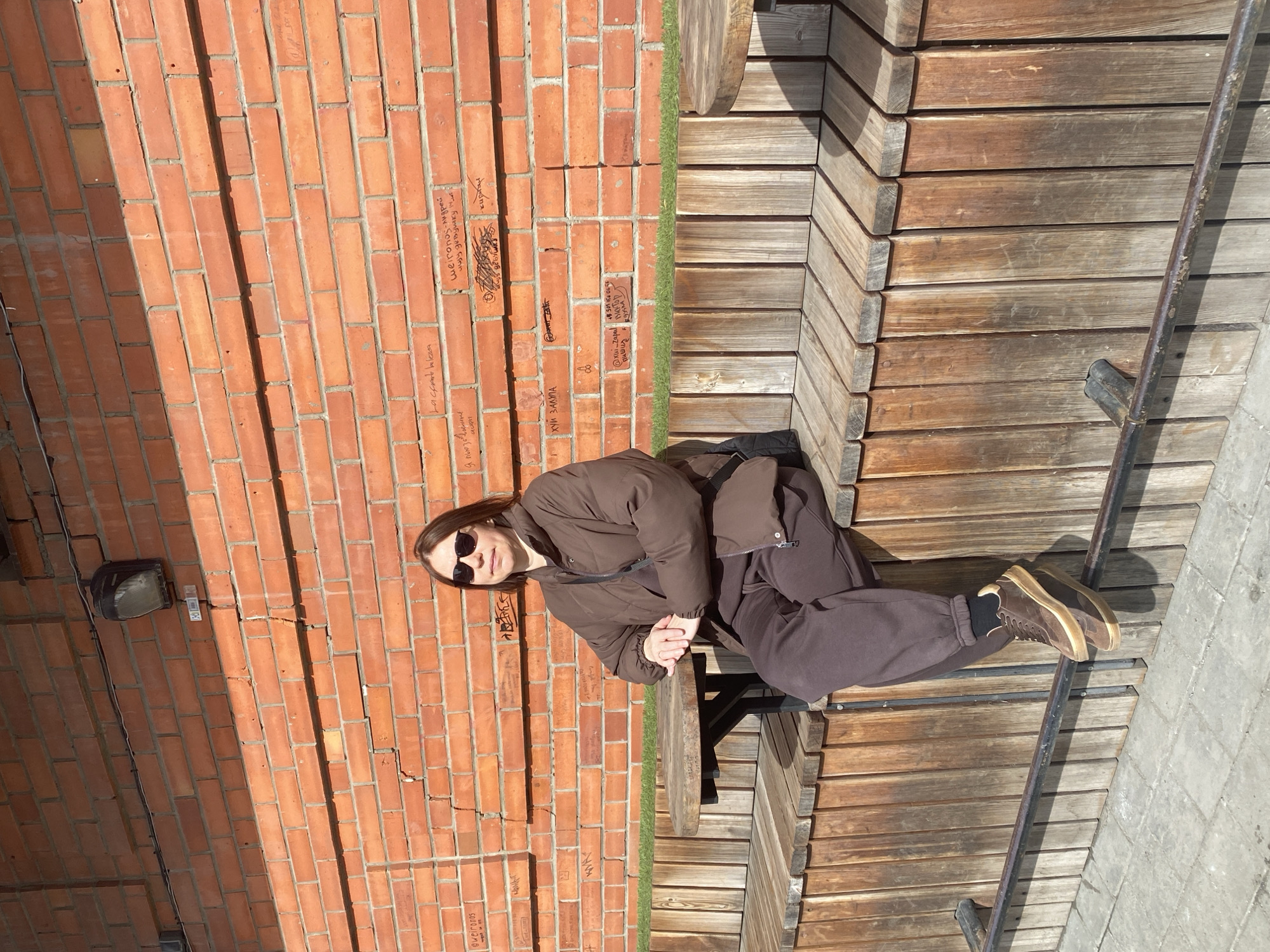 Woman rests on wooden benches in Yekaterinburg pedestrian area