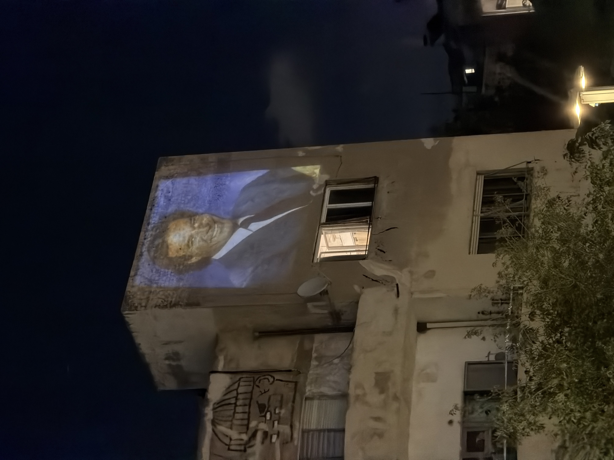 Large portrait projected onto Tel Aviv building at night