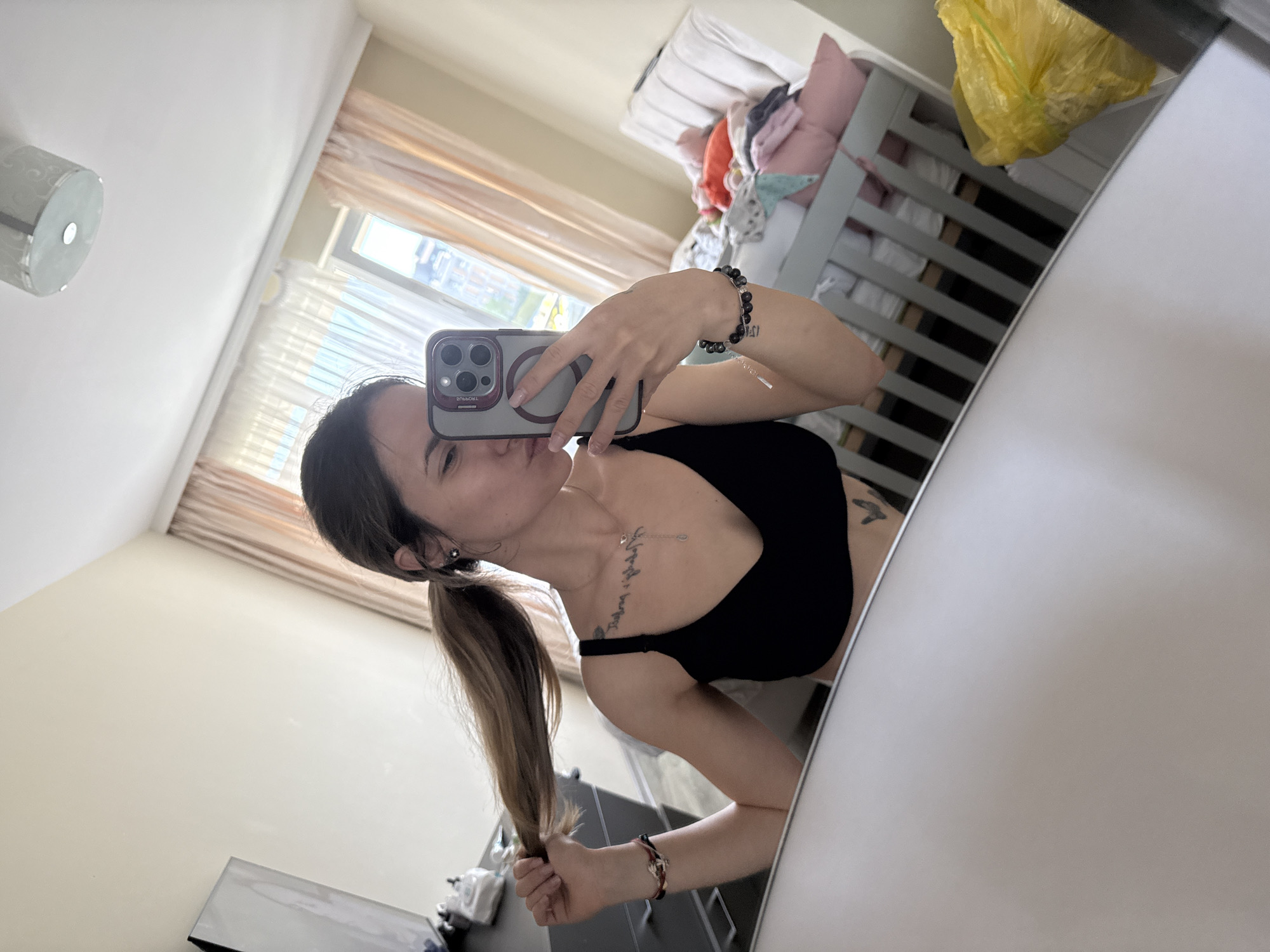 Woman takes mirror selfie, baby rests in Sofia home