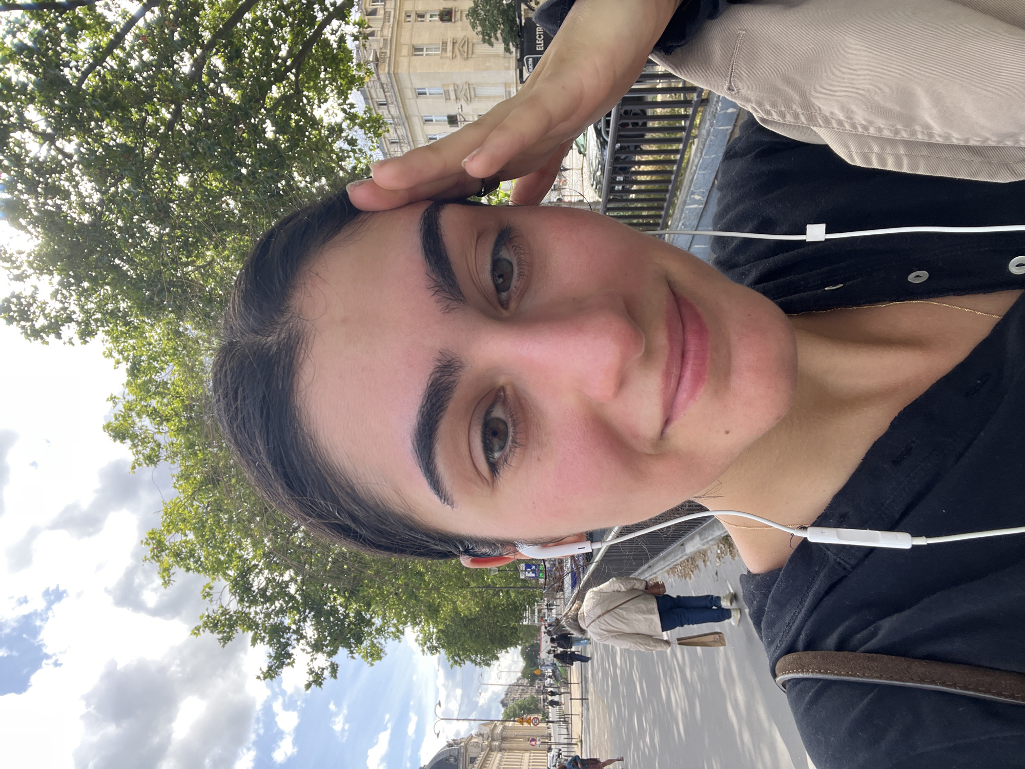 Woman takes selfies on Paris sidewalk