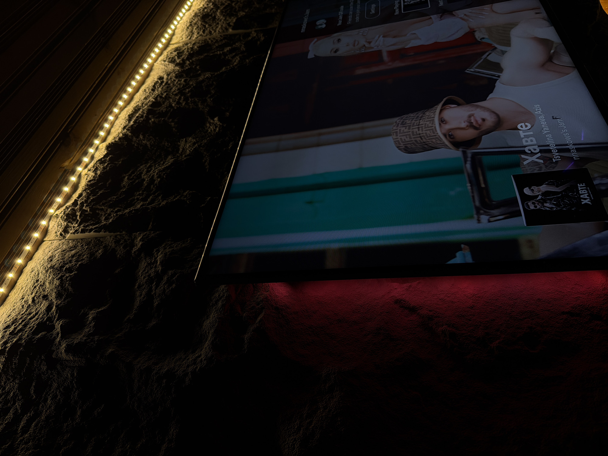 Indoor evening scene features lit wall and active fireplace