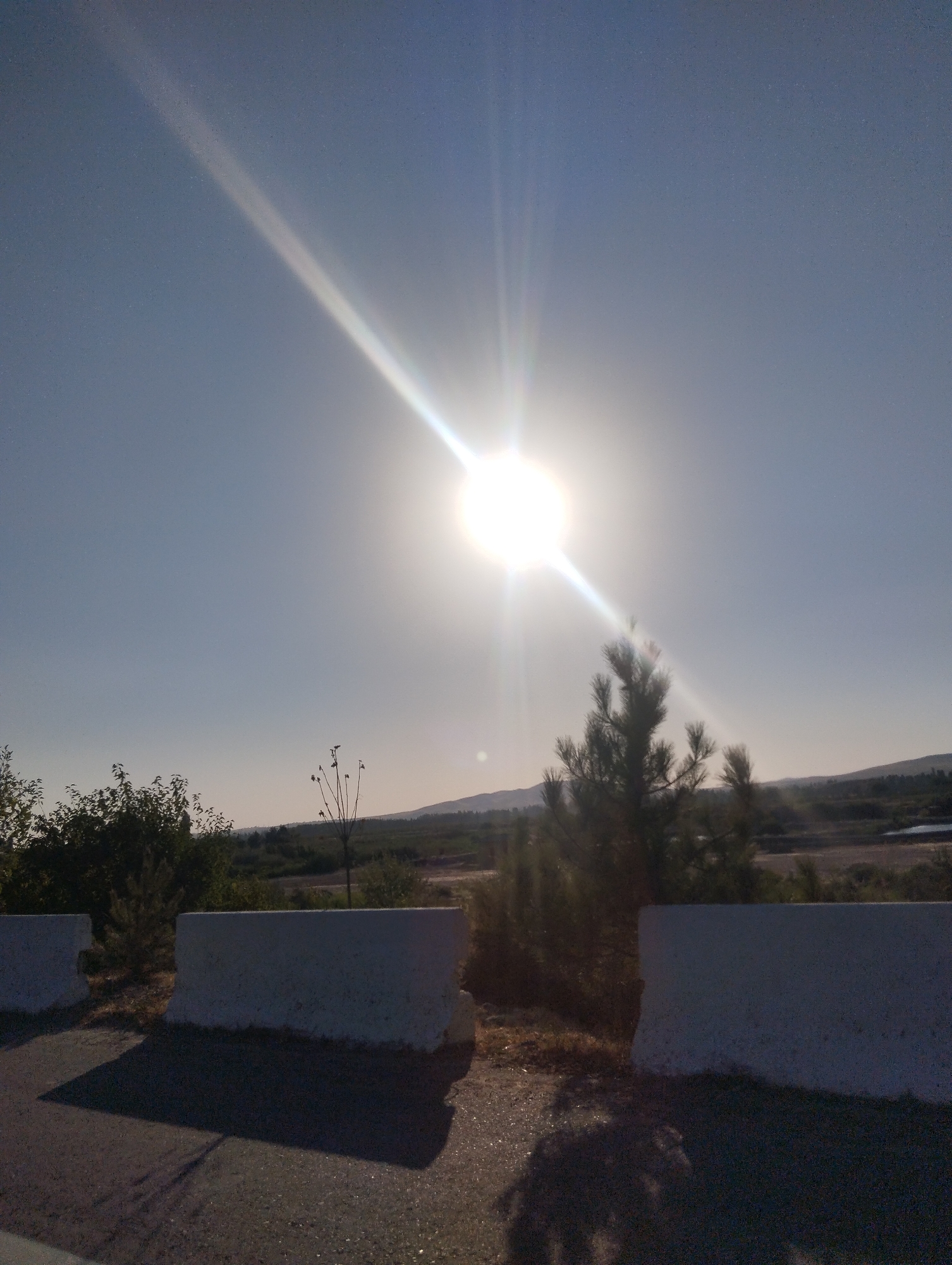 Driving through dry hill country under a harsh midday sun