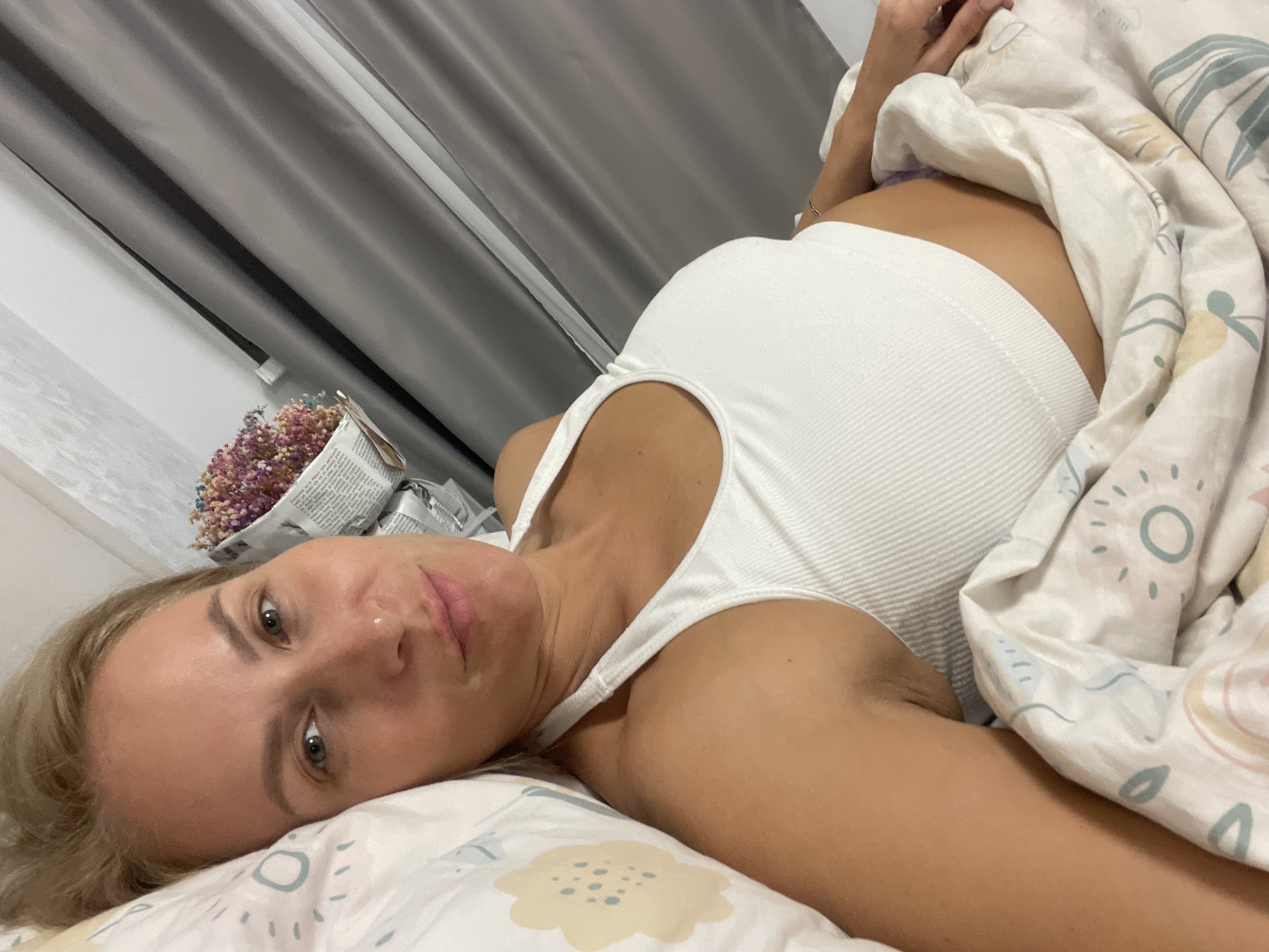 Woman rests on bed in Baranovka home