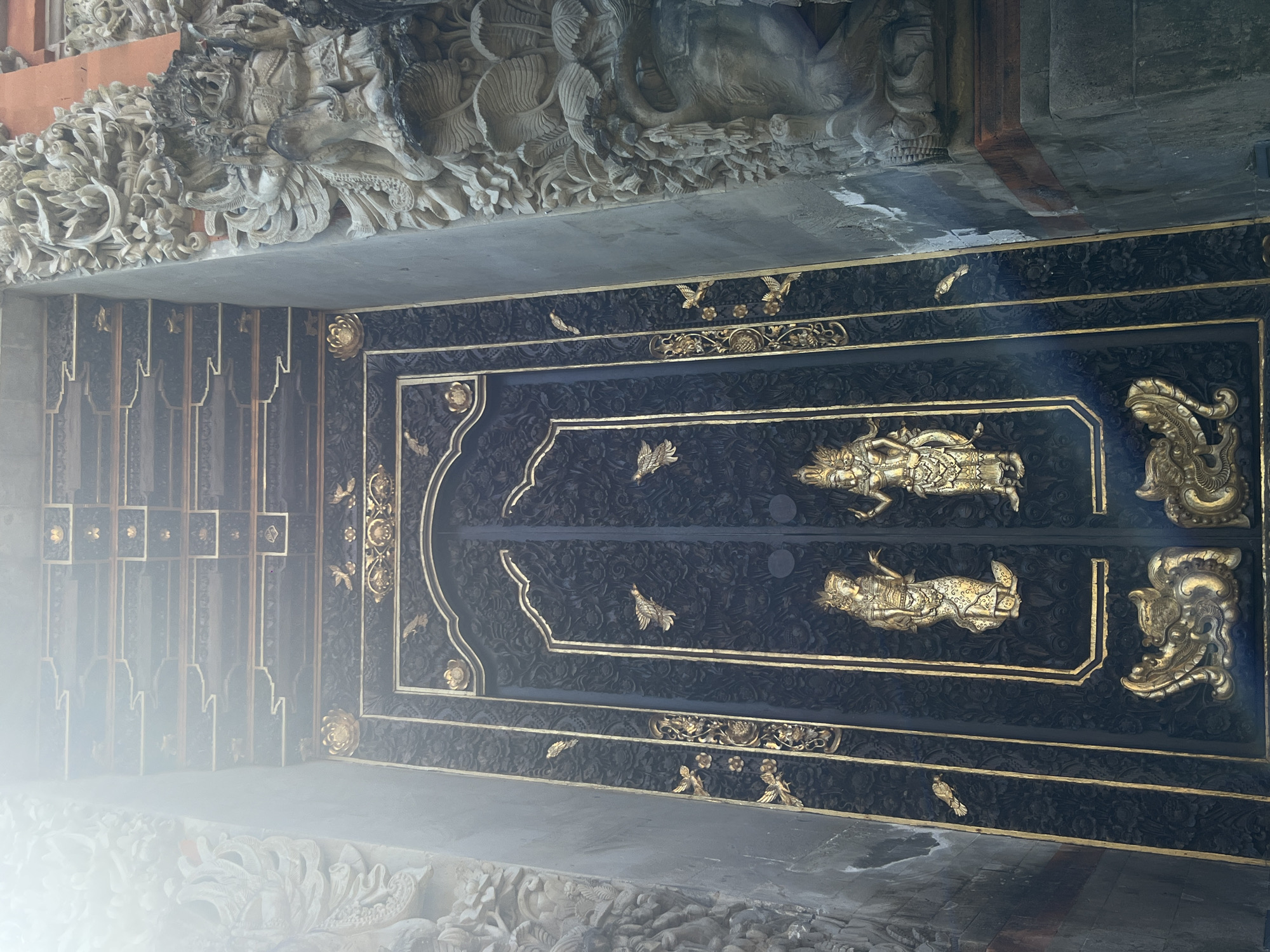 Tourist documents ornate Balinese temple architecture in Ubud