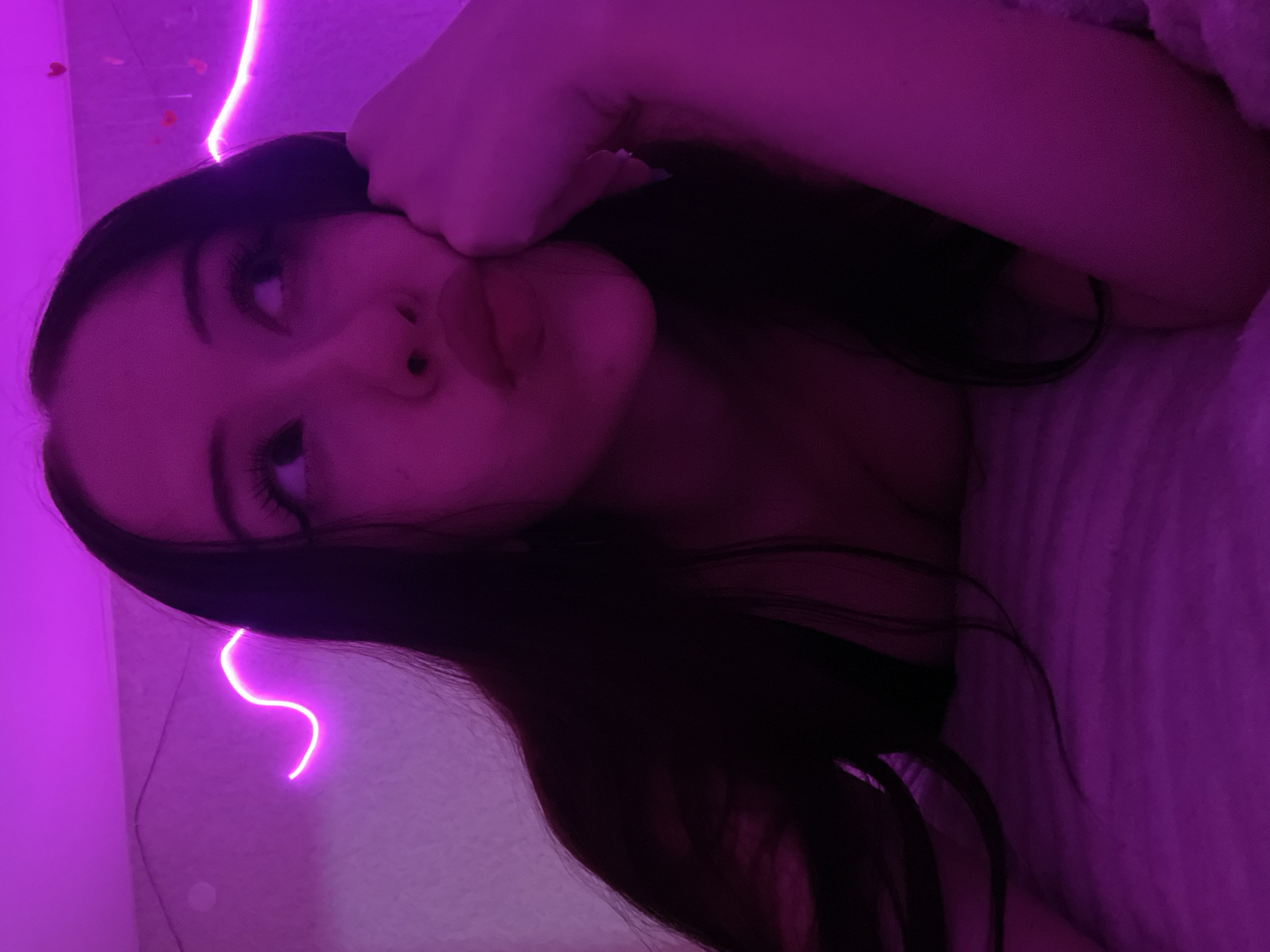 Bedroom self-portrait session under pink and purple neon lights