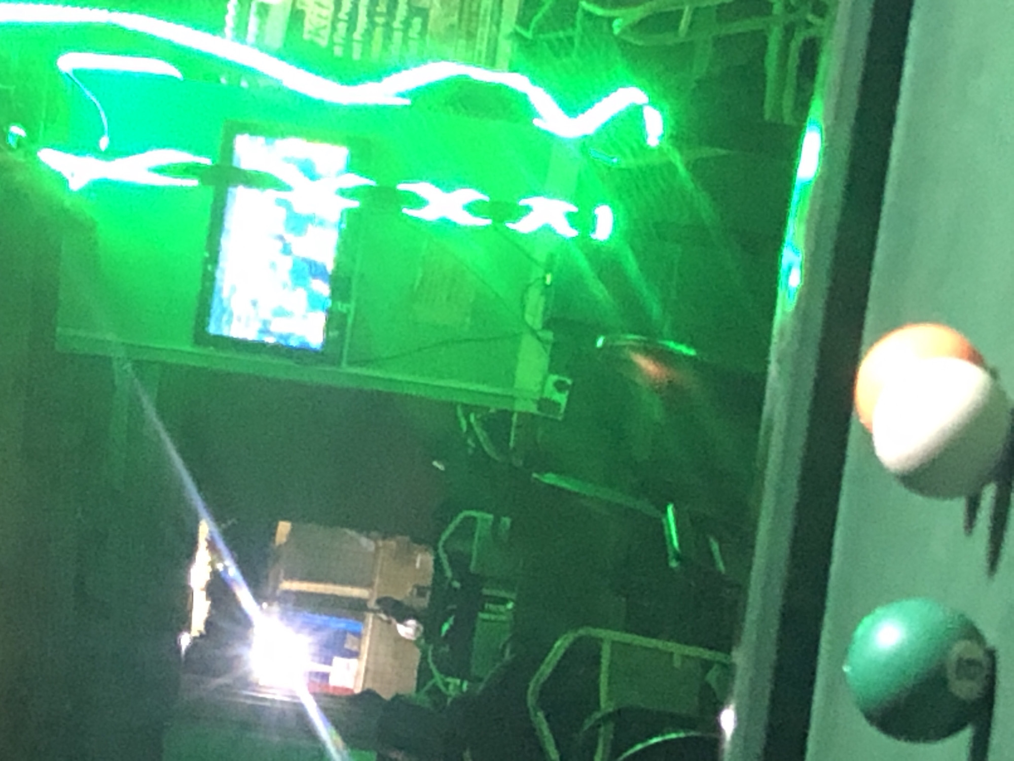 Pool hall gathering captured under green neon lights