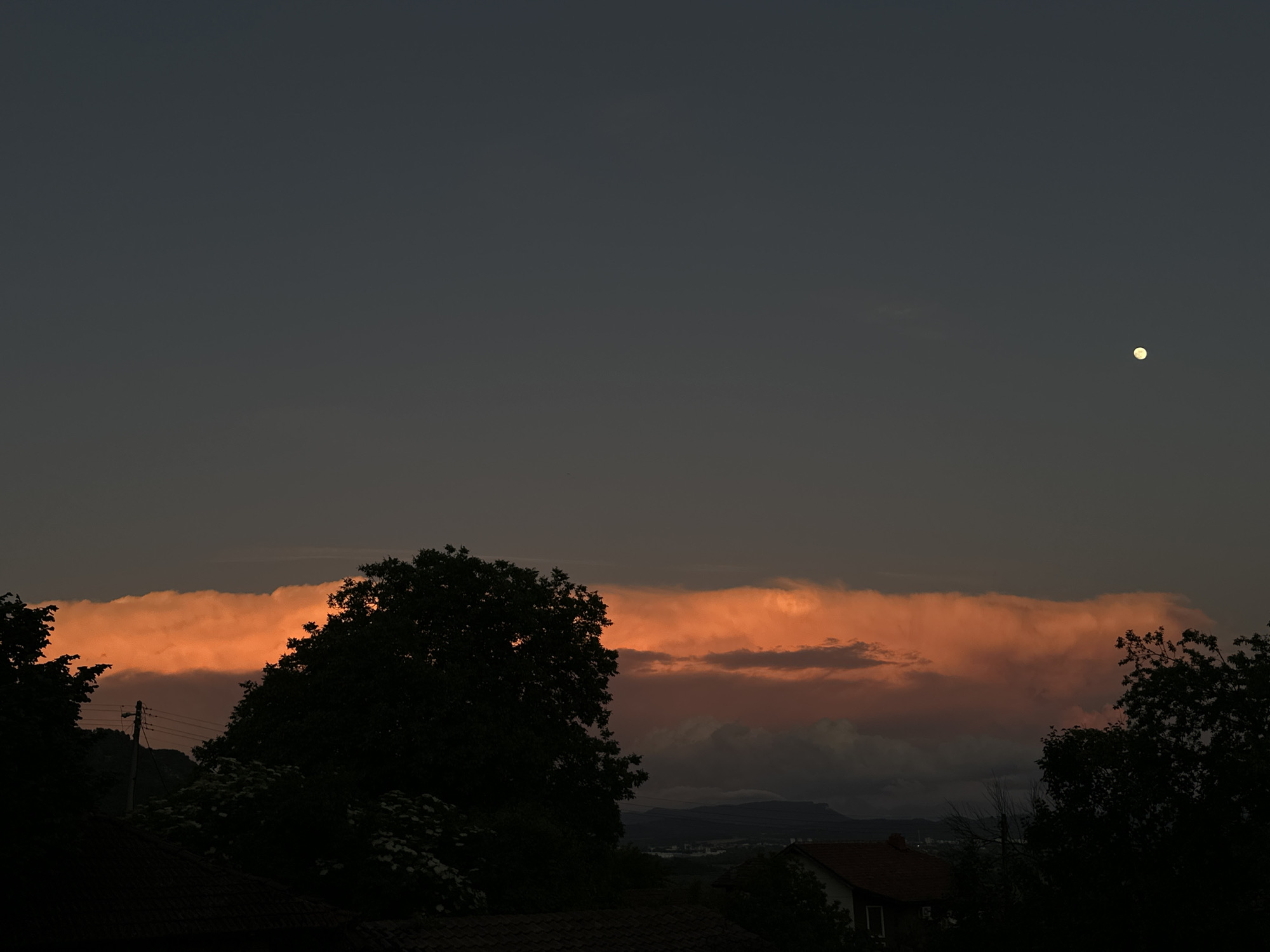 Orange cloud band illuminates evening sky over Kormiansko, Bulgaria