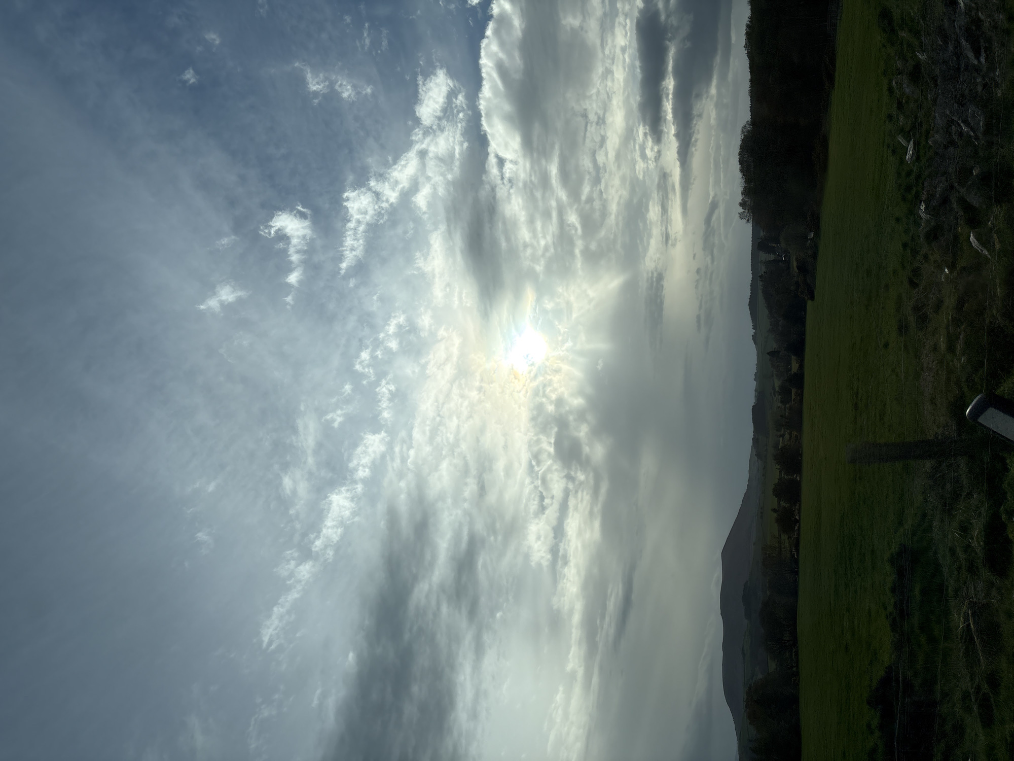 Sunlight breaks through clouds over Shelve countryside fields