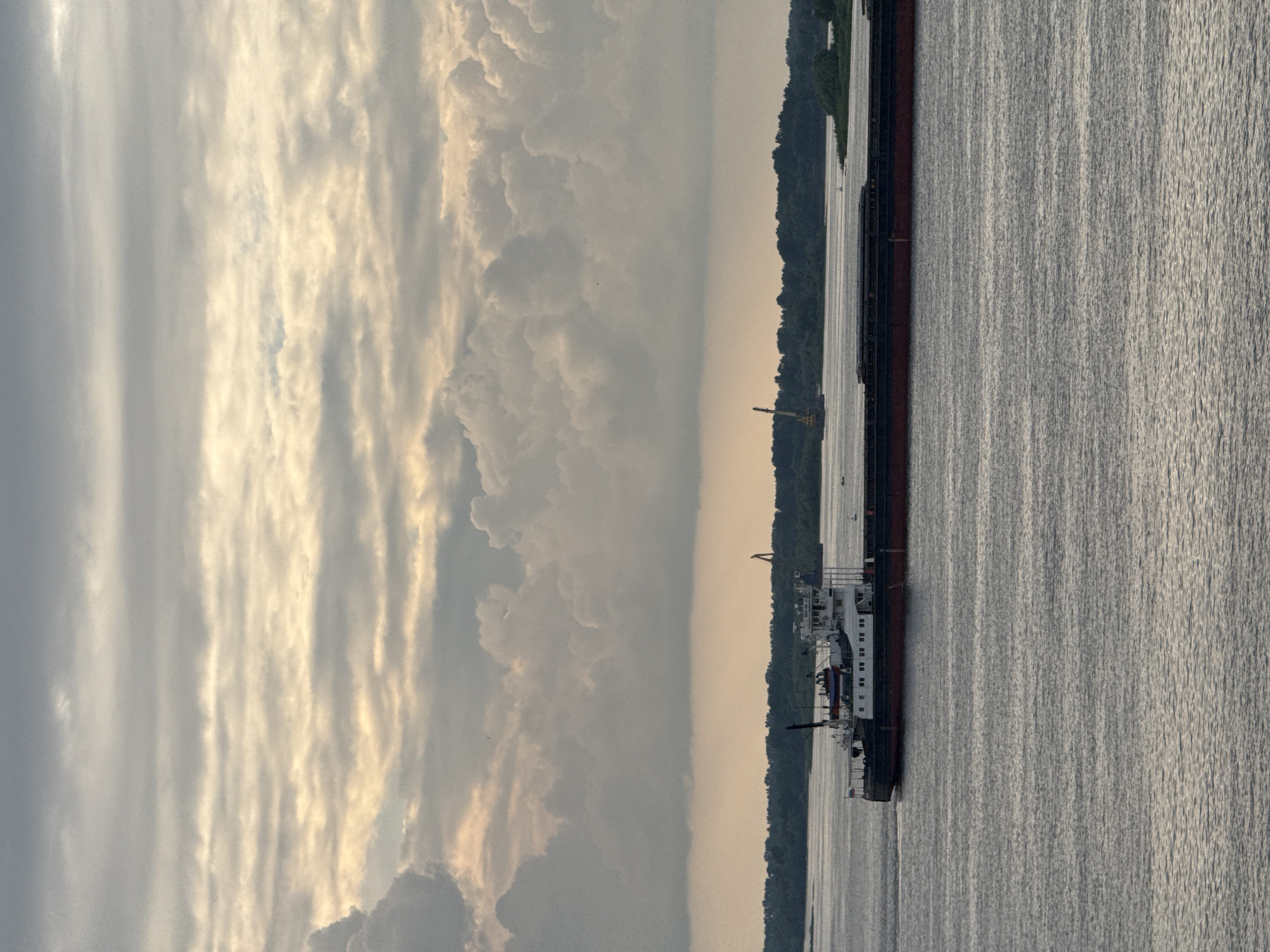 Cargo barge on the Volga under a layered sunset sky