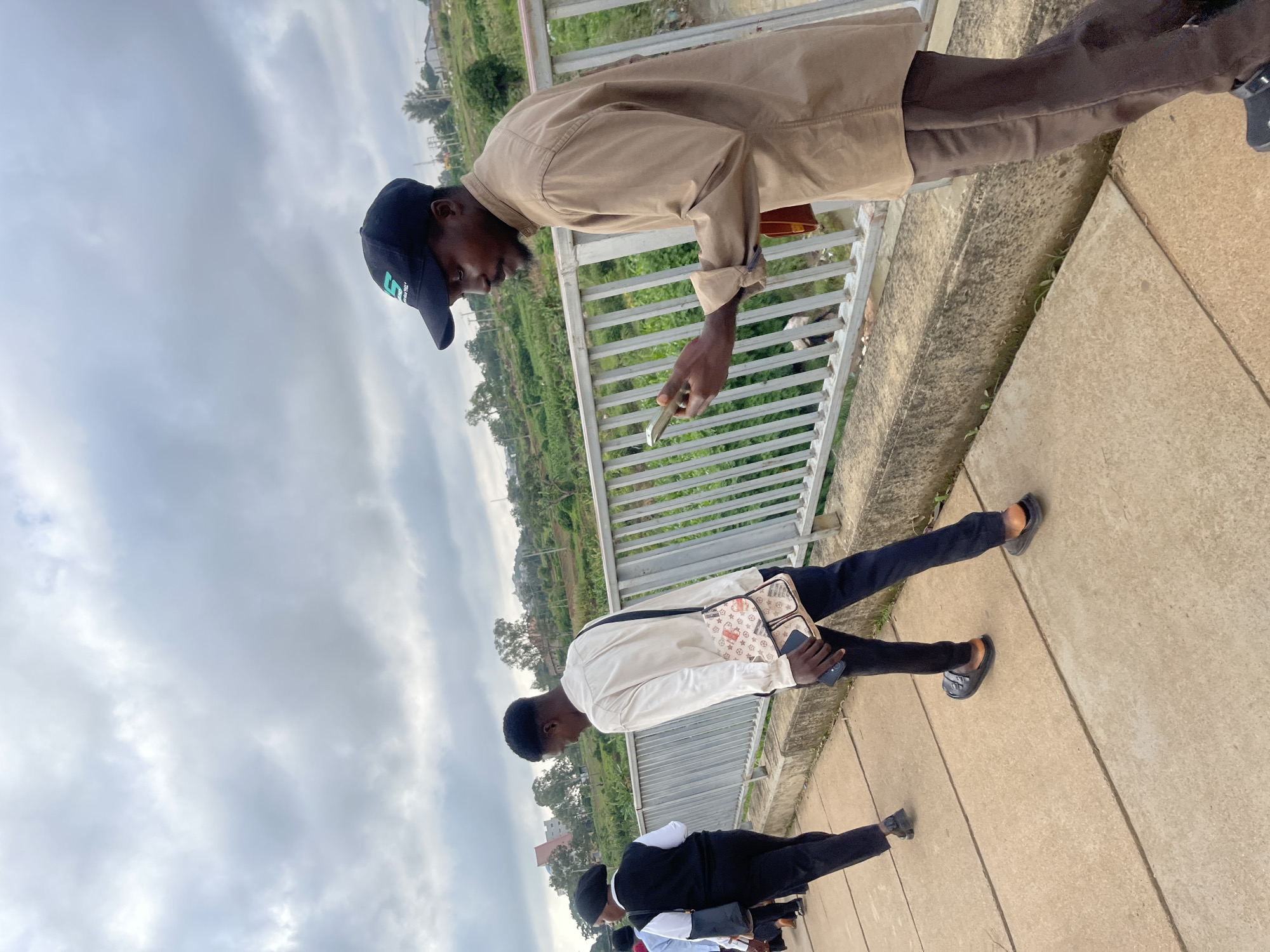 Morning foot traffic and motorbikes on a Nigerian campus bridge