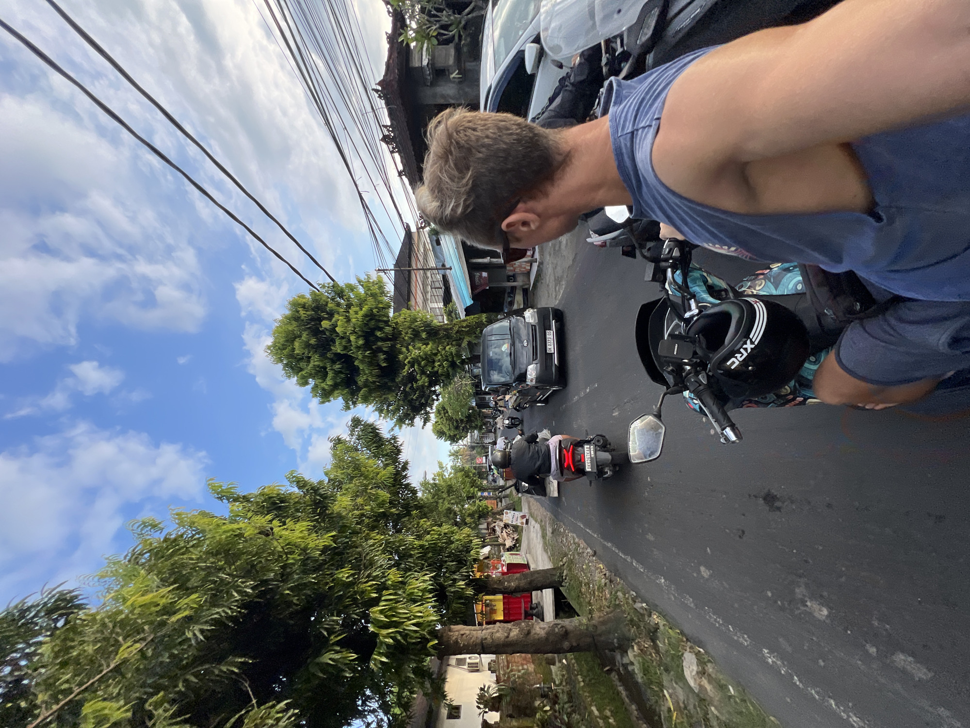 Motorcyclist navigates typical urban traffic in Sayan, Indonesia