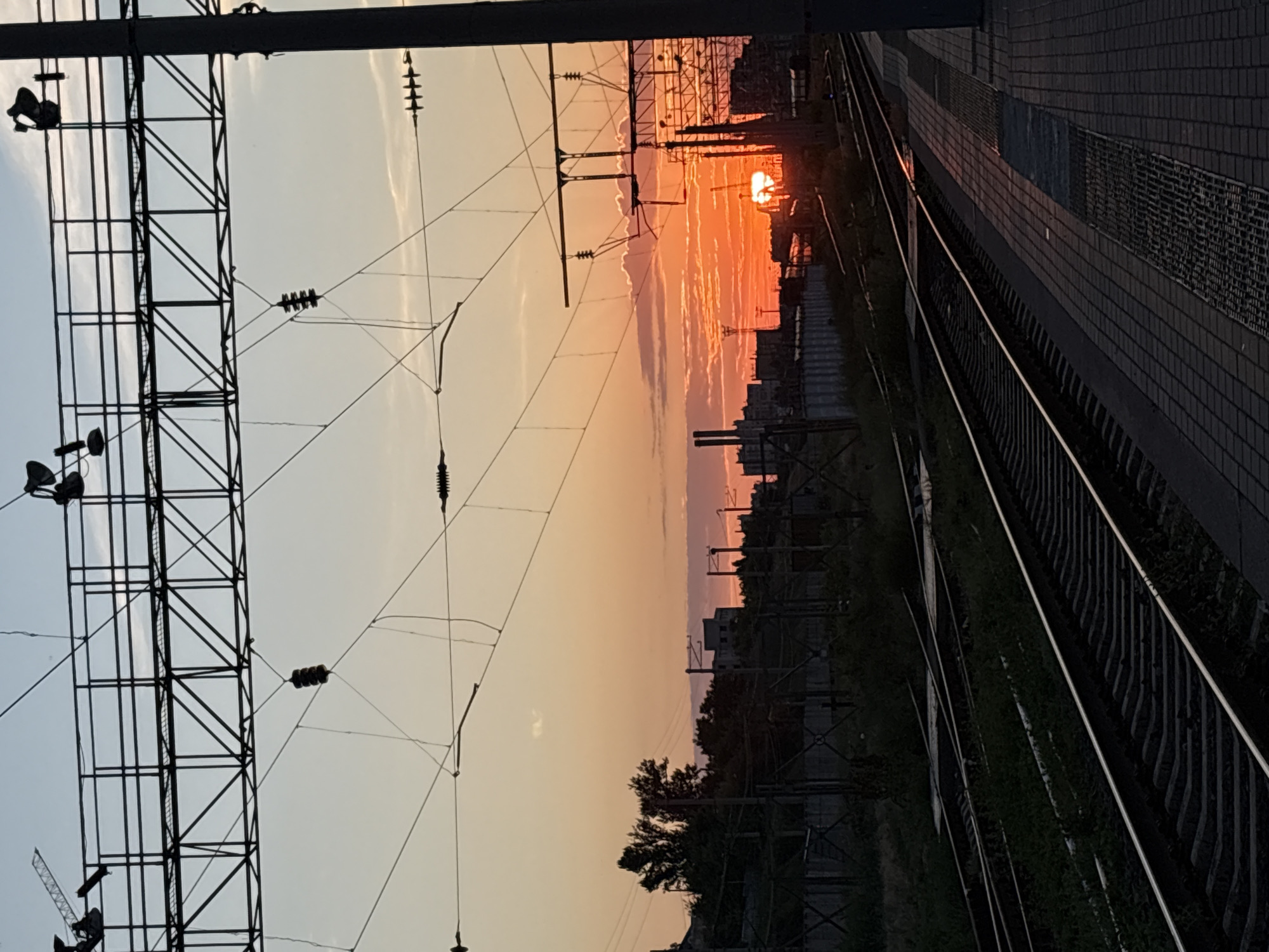 Sunset scenes documented at Volgograd railway station with trains, flags