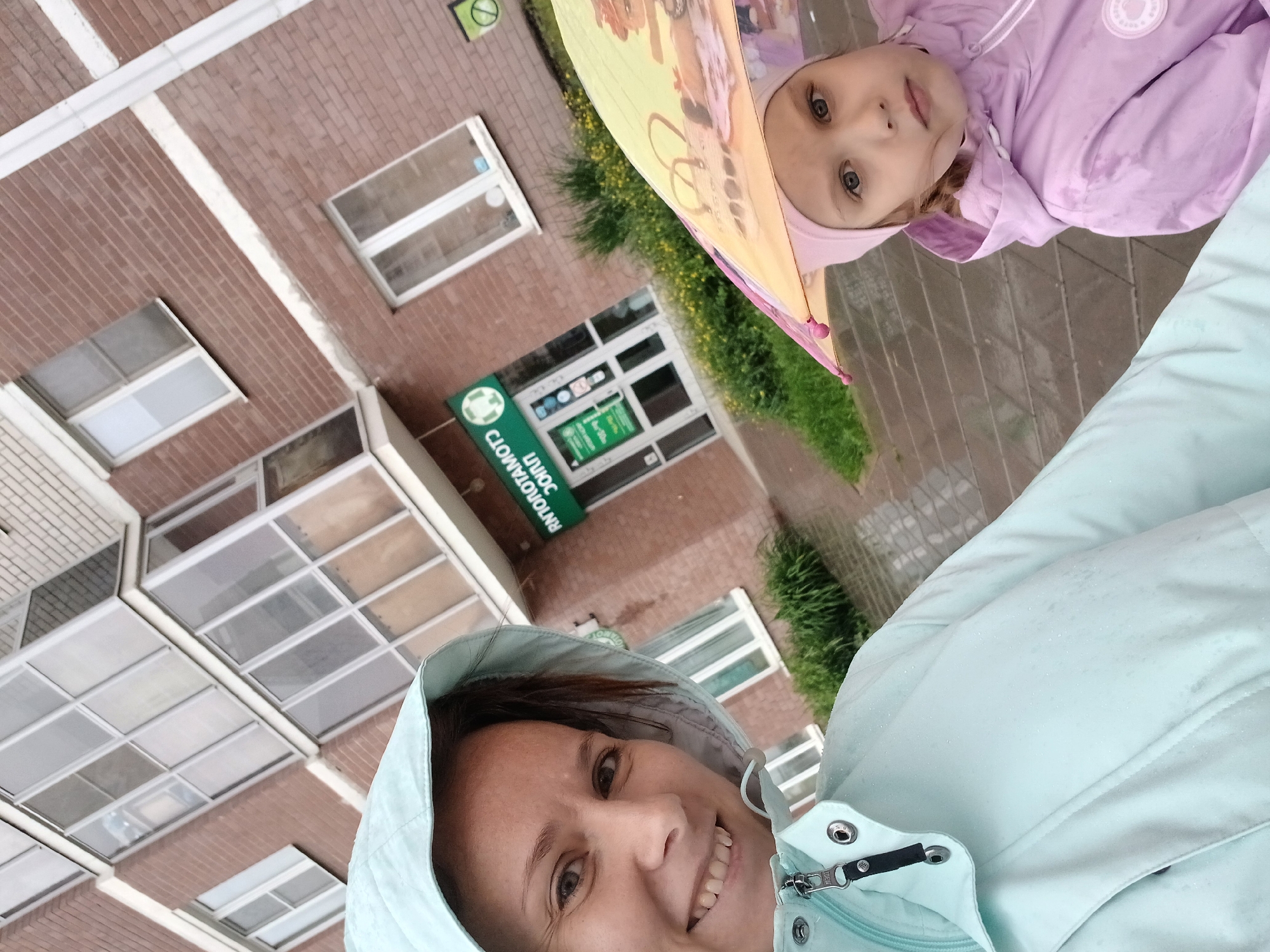Woman takes selfie with girl during rainy day in Yekaterinburg
