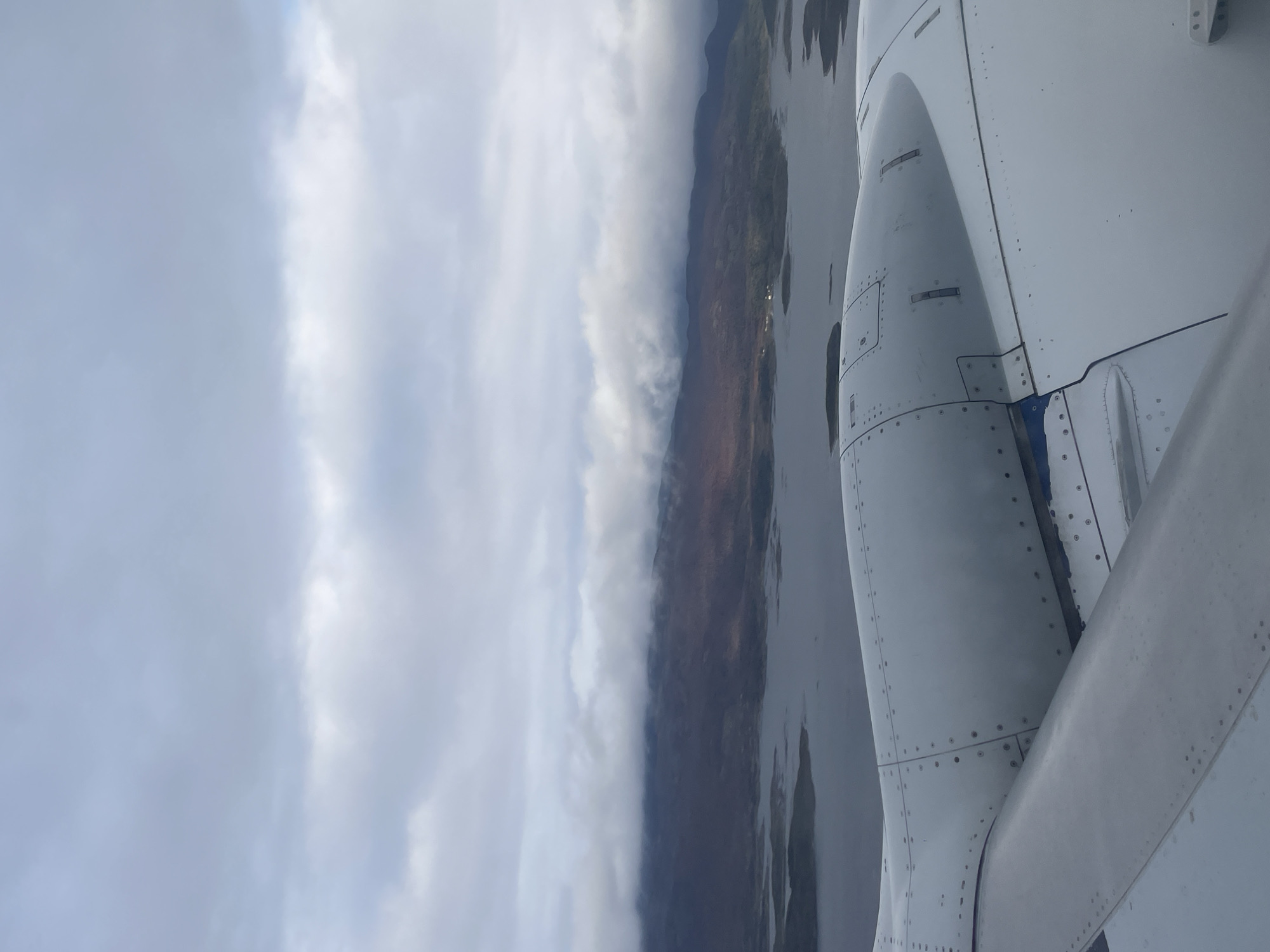 Airplane wing and engine viewed from passenger window over Argentina