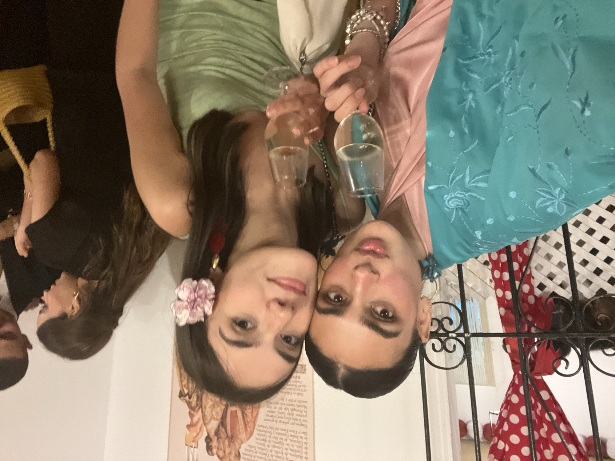 Two women toast with sherry in late-night Sevilla celebration