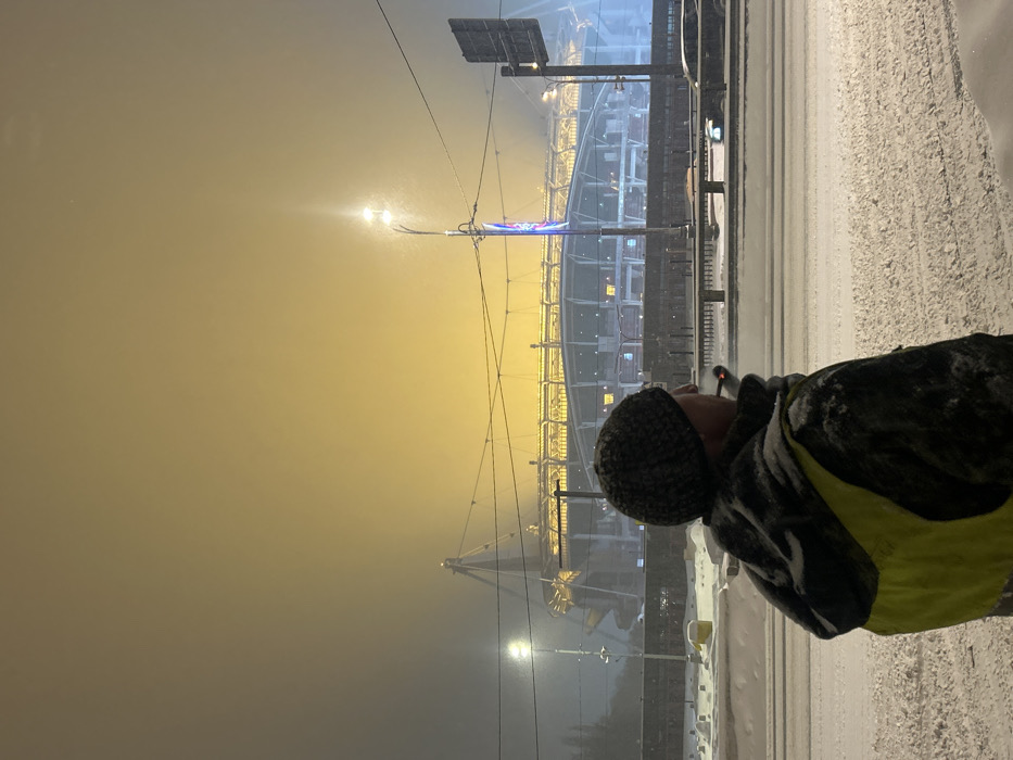Snowy evening scene near Moscow stadium with waiting pedestrians
